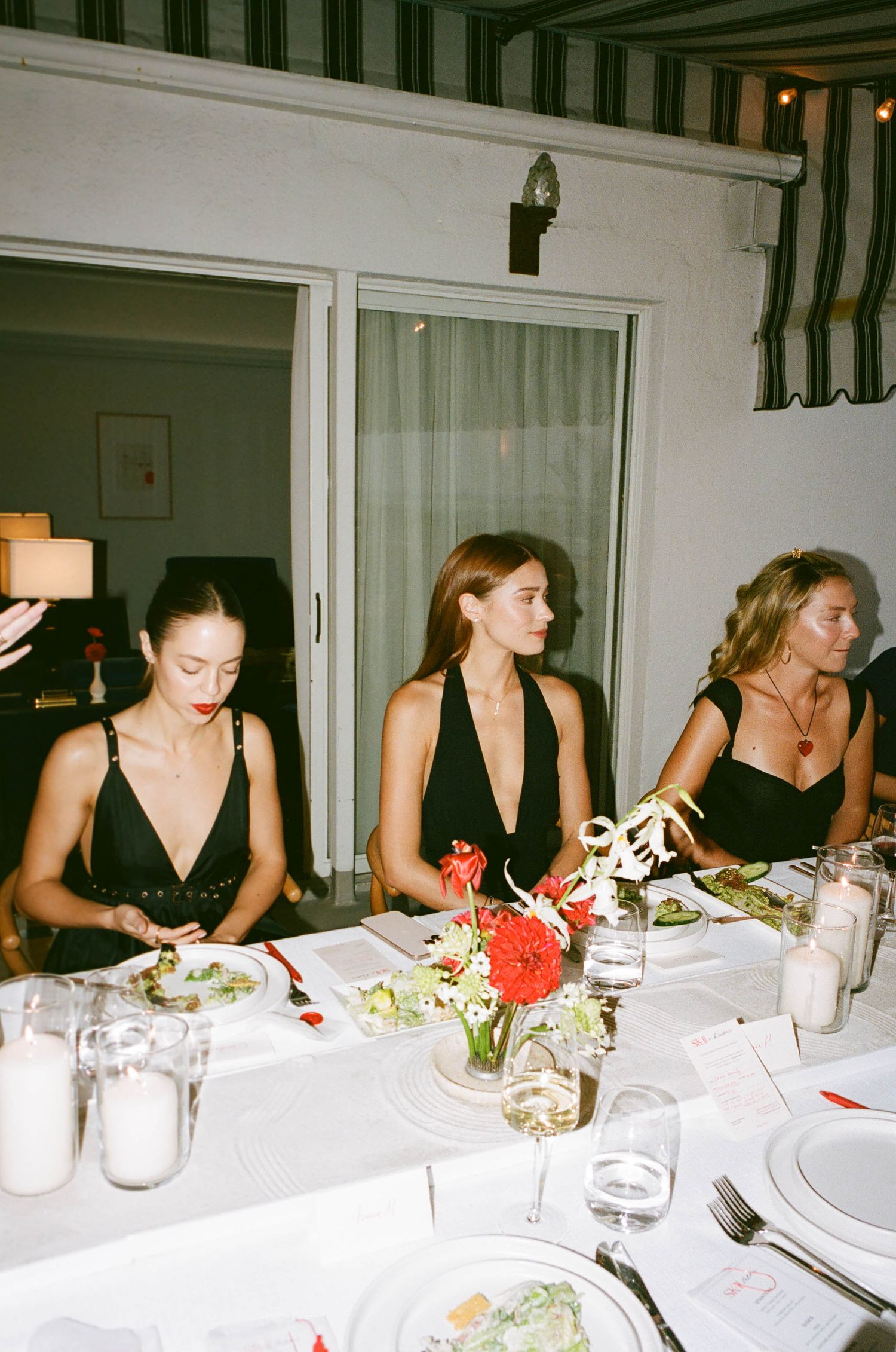 Elegant dinner party setup with white tablecloth and floral centerpieces.