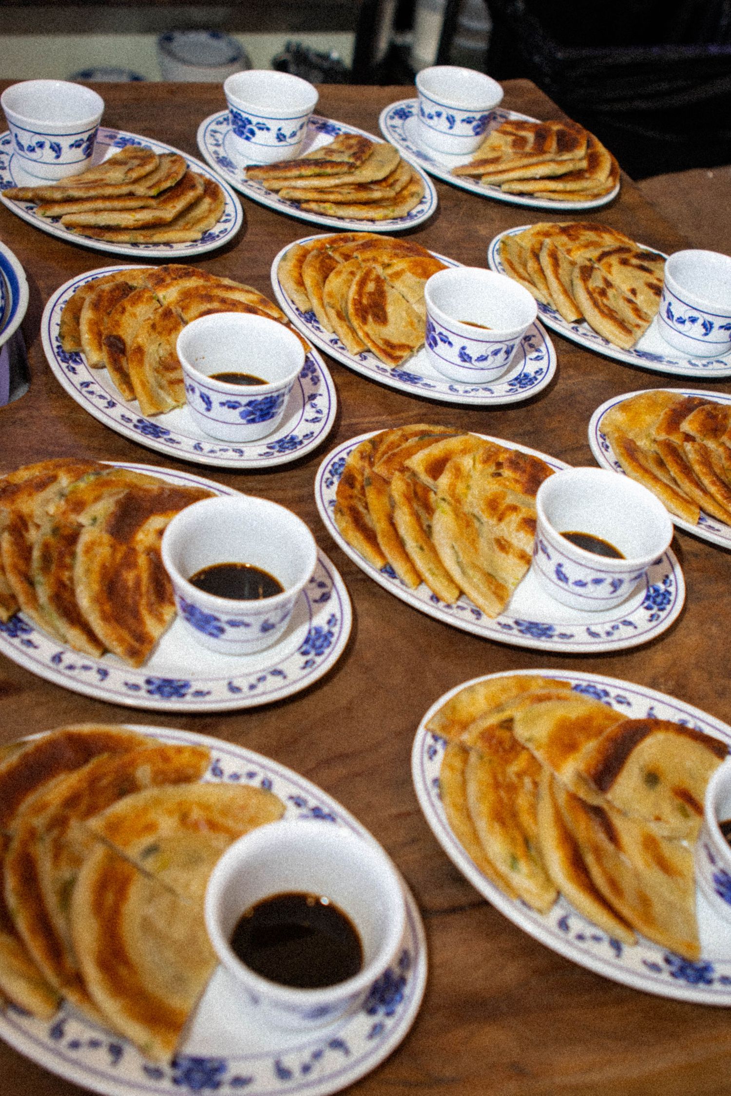 Traditional Chinese pancakes served with tea in blue and white porcelain dishes.