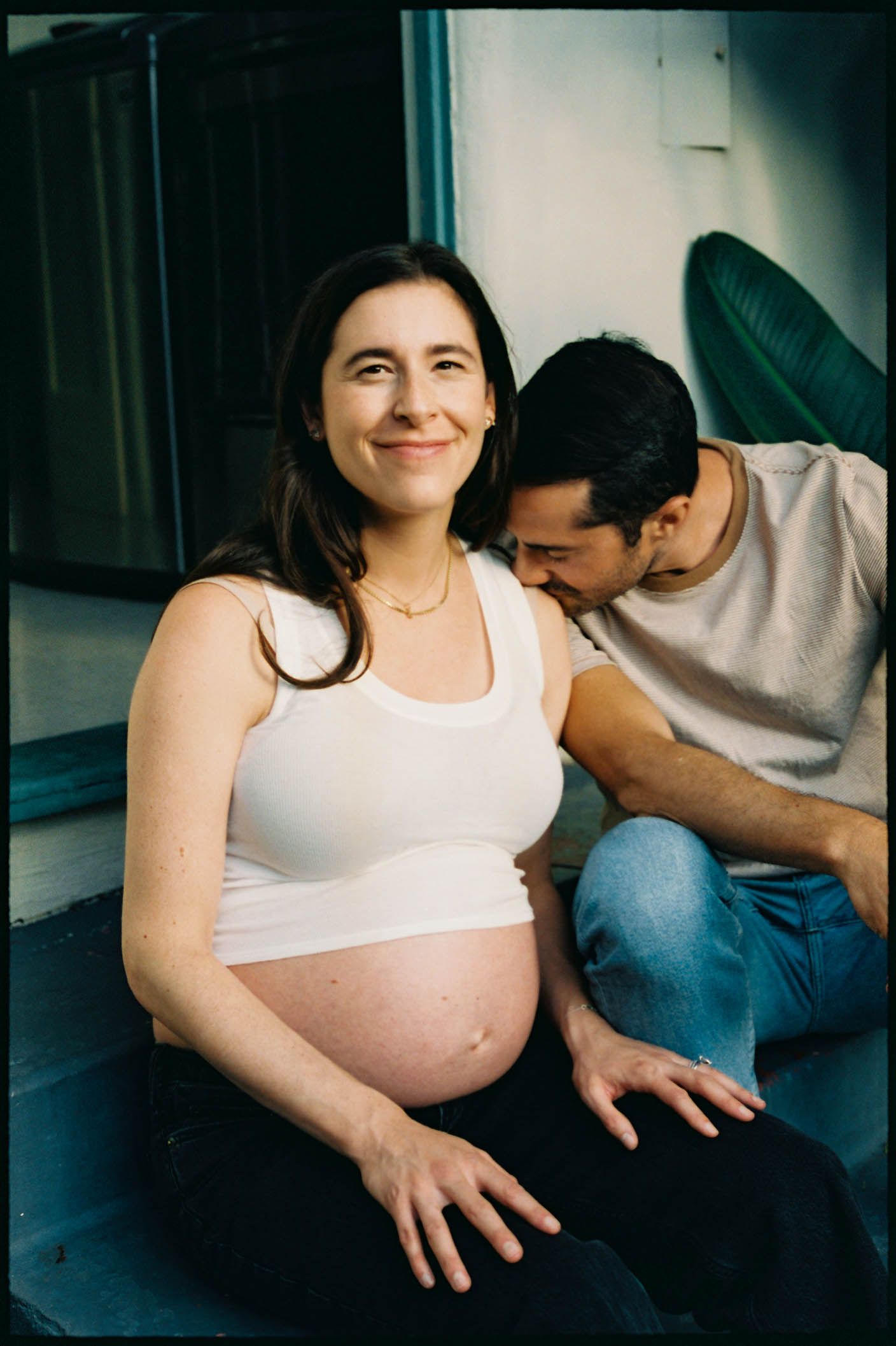Intimate maternity photo series showing a couple on a couch.