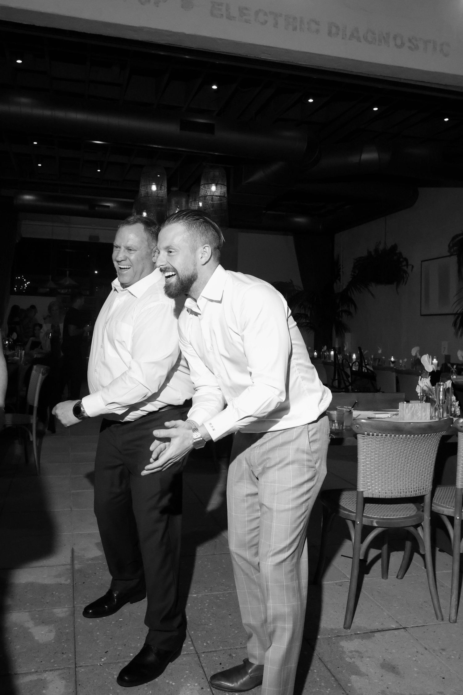 People in formal attire dancing in a dimly lit venue.