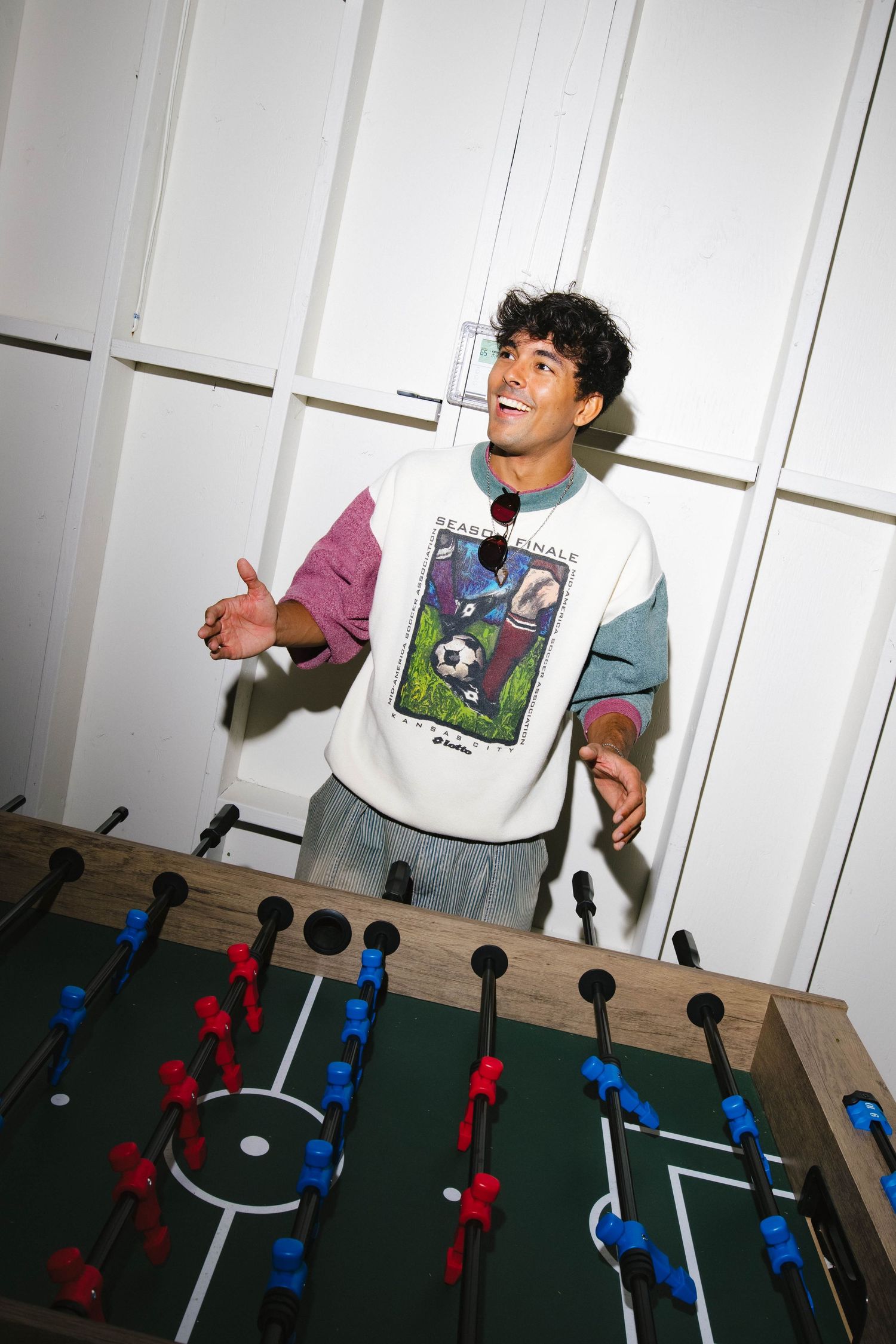 People playing foosball table game in casual setting.