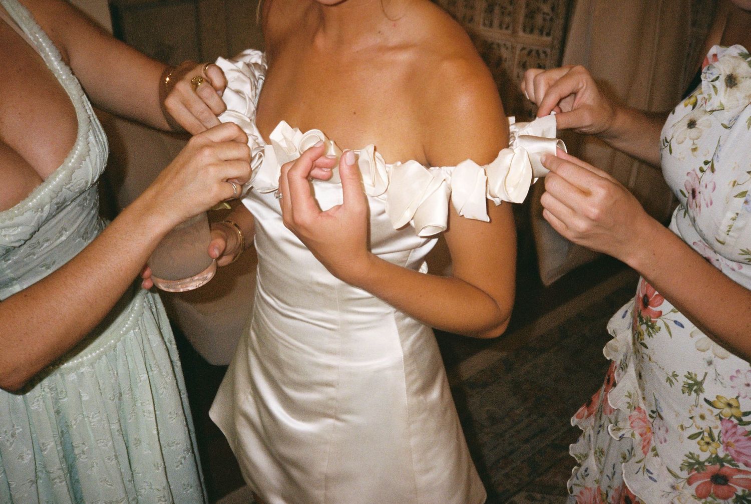 Close-up shots of hands adjusting wedding dress details.
