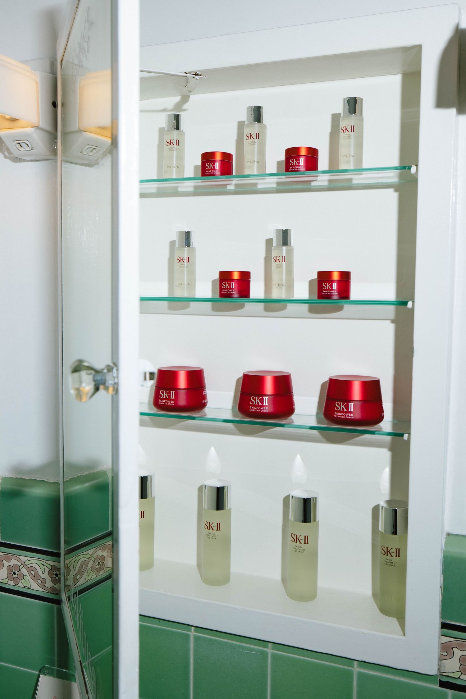 Modern white shelving display with glass panels showcasing skincare products in red packaging.