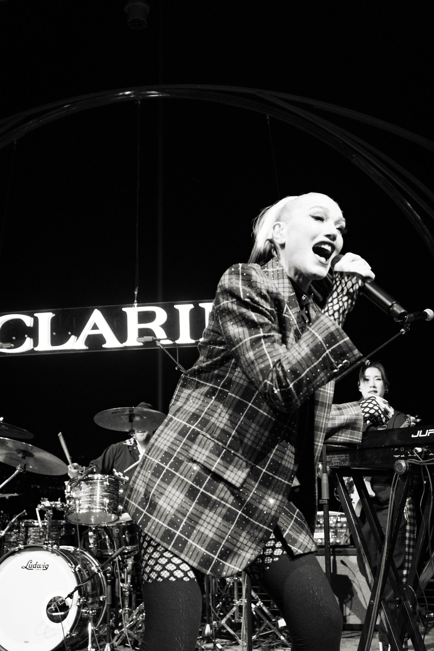 Black and white photo of performer singing at Clarins branded event.