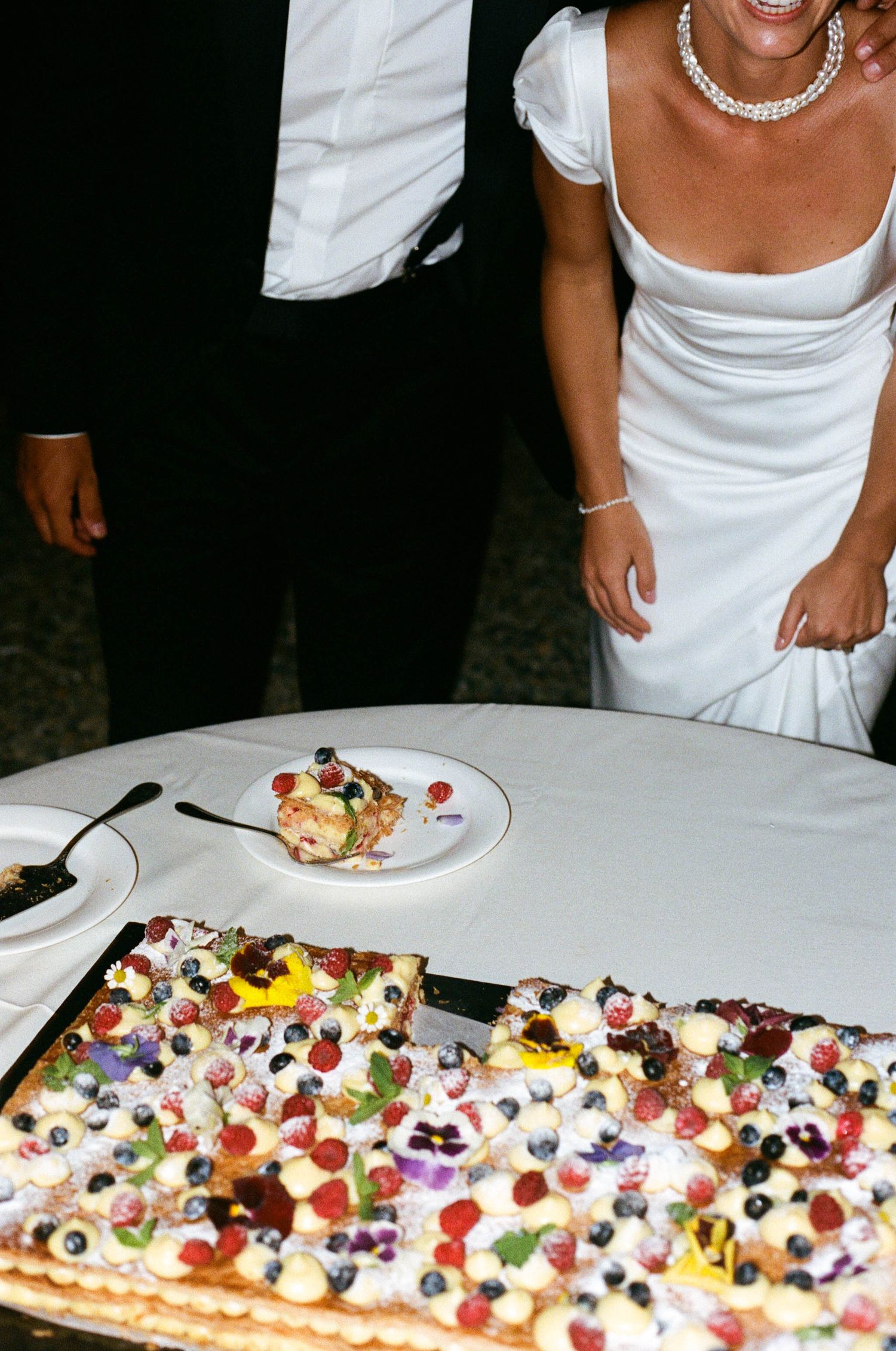 Beautifully decorated dessert table with colorful berries and fruits at a wedding reception.