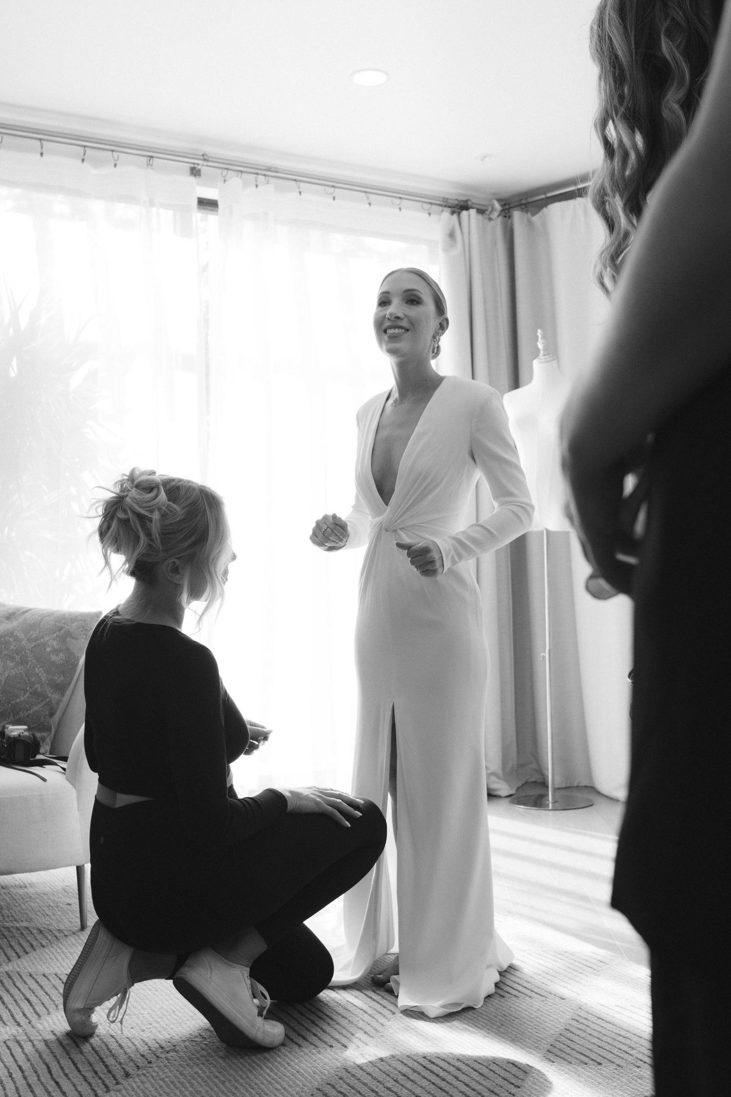 Black and white candid shots of wedding preparation moments in a bright room.
