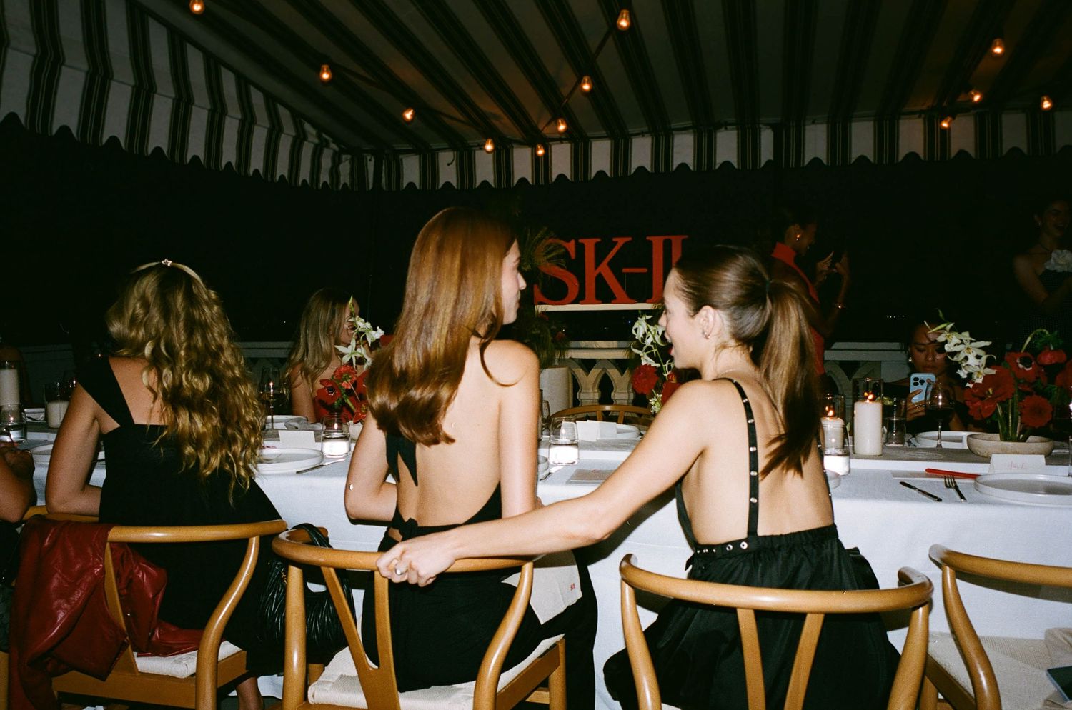 Dark interior setting with string lights and people seated at tables.