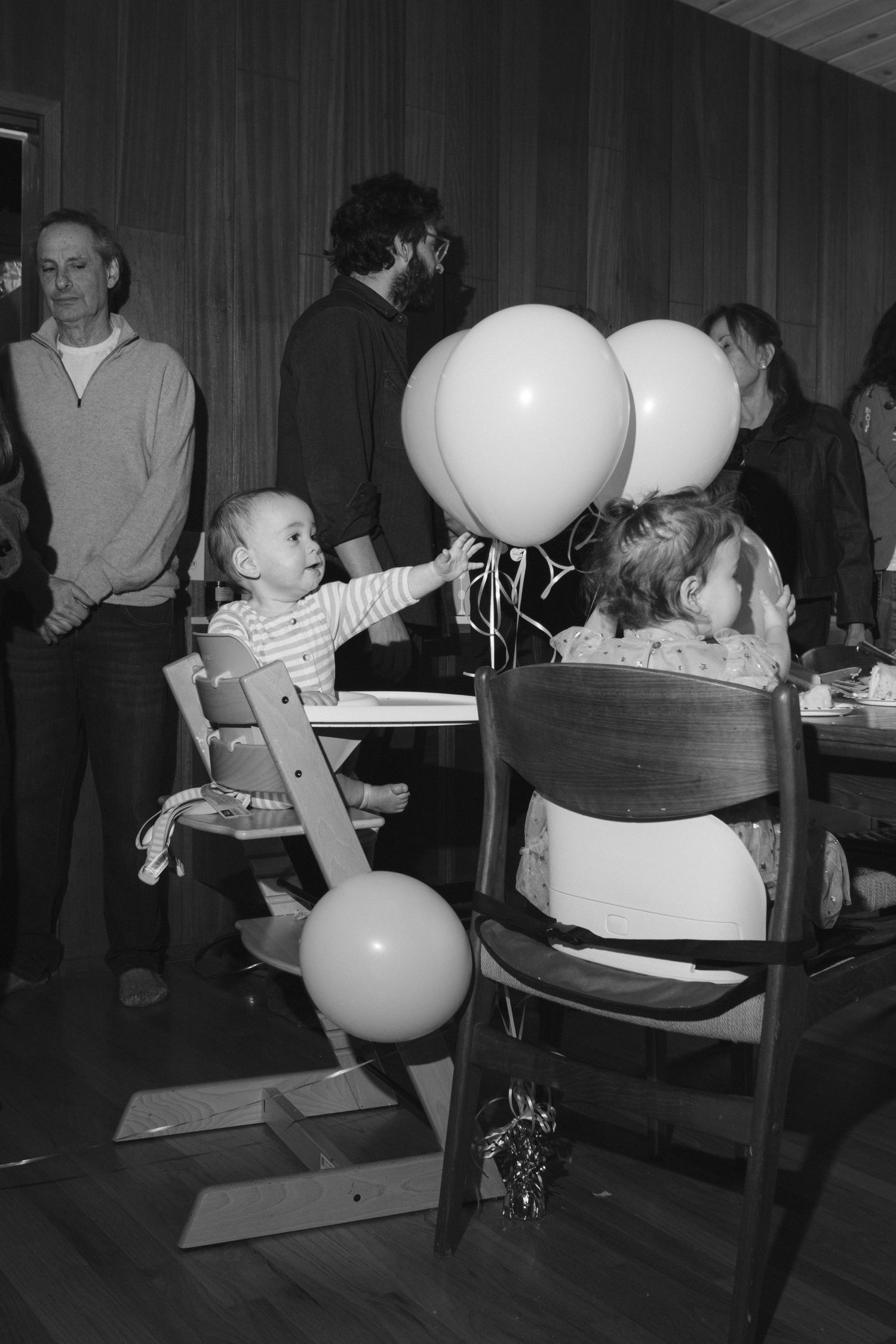 Black and white photo of chairs and balloons at an indoor event.