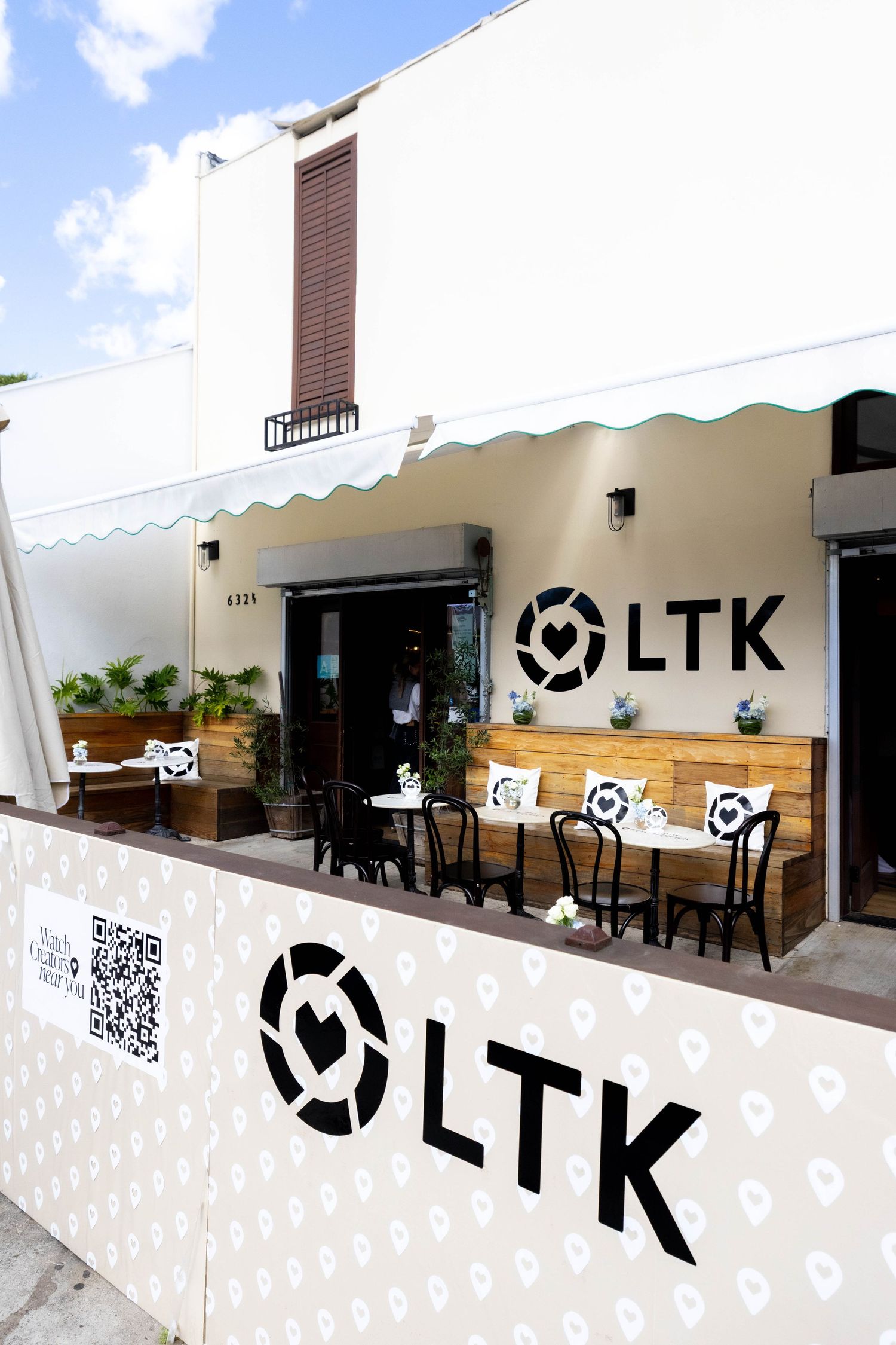 Outdoor patio area with white walls featuring LTK logos and heart pattern designs.