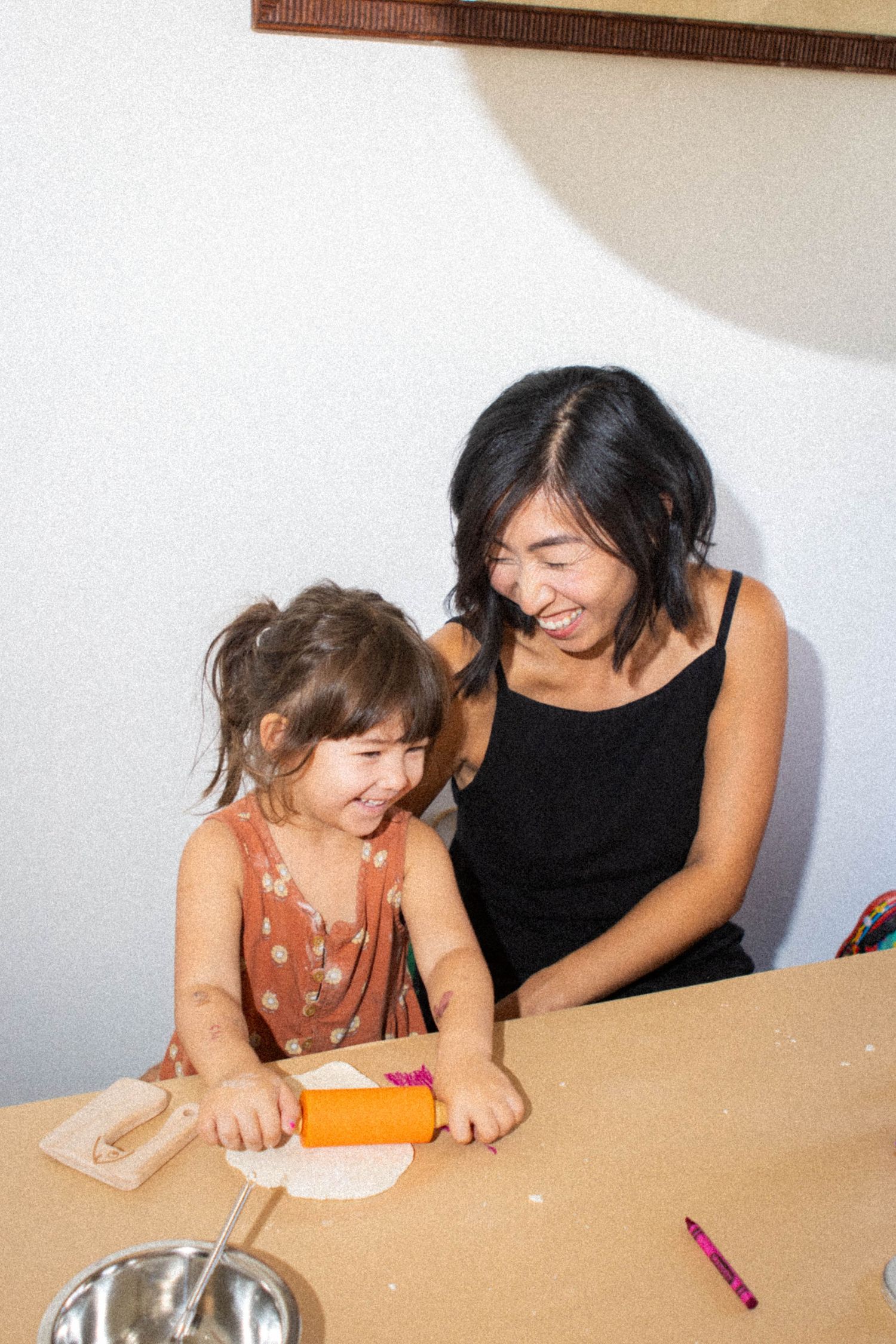 Two people working together on a craft project at a table.
