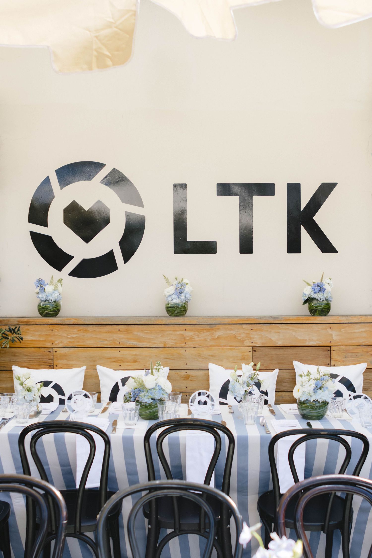 Modern restaurant interior with LTK branding on wall and striped chair cushions.