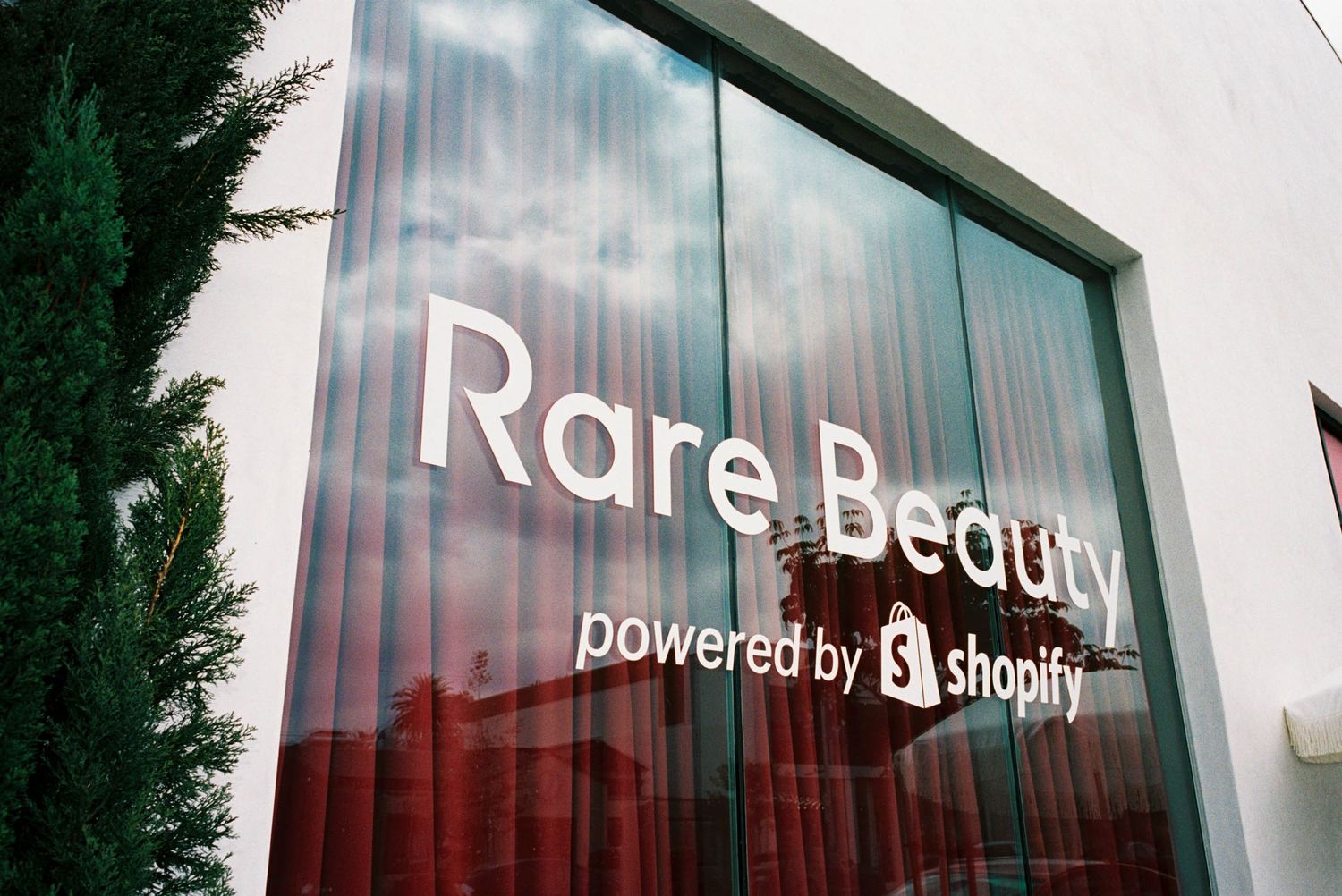 Storefront exterior with illuminated Rare Beauty signage powered by Shopify.