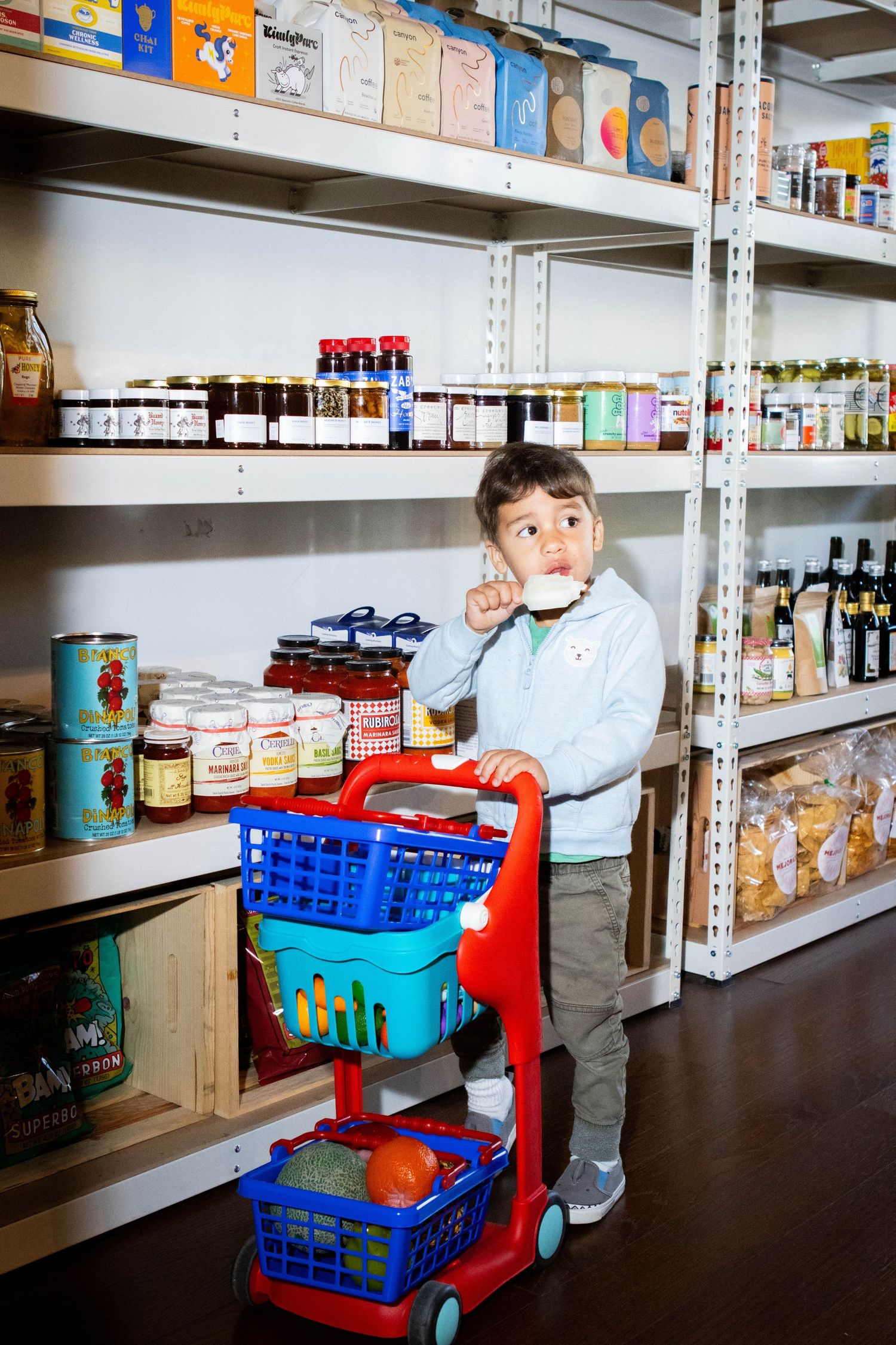 Storage shelves stocked with food items and supplies in a pantry setting.