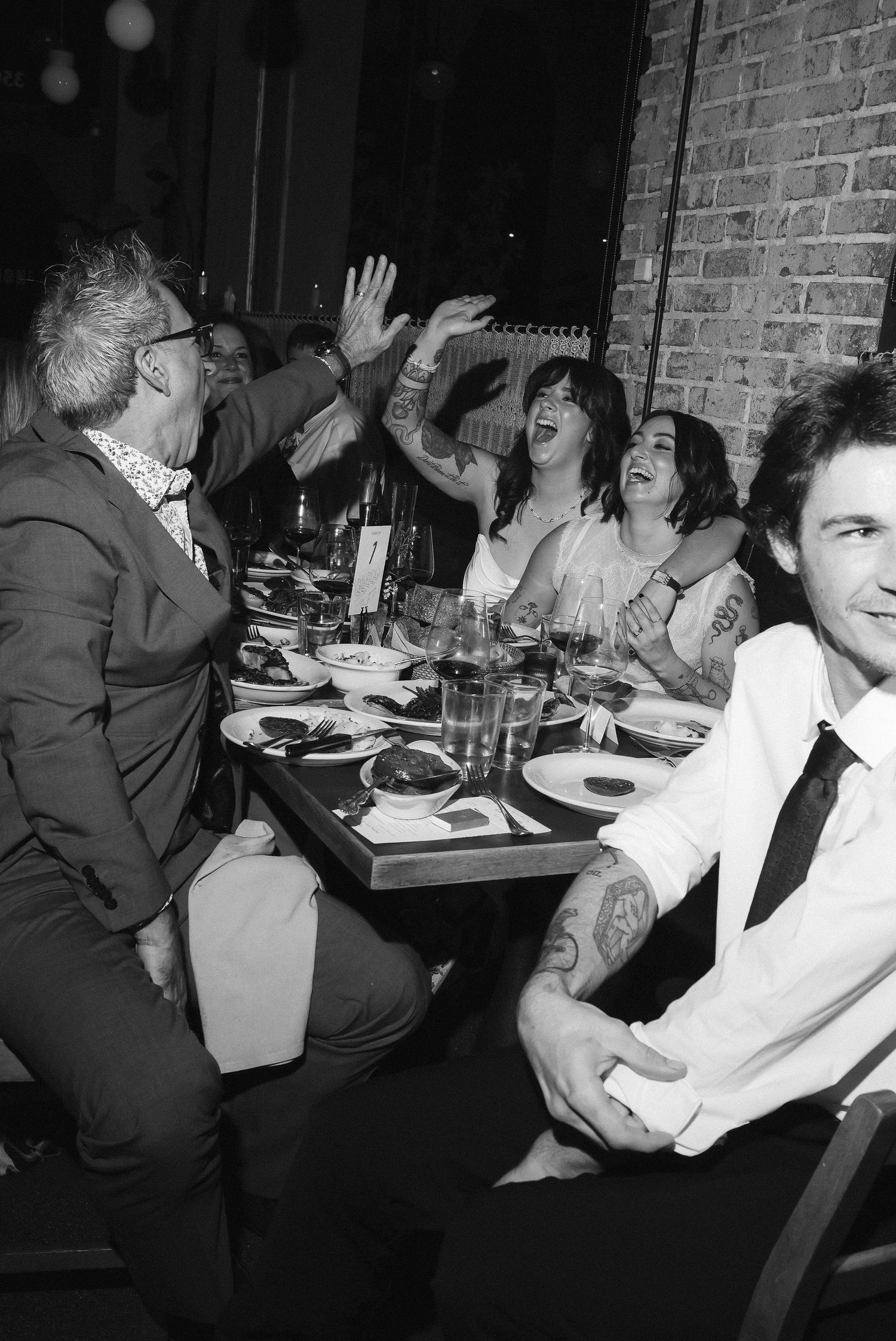 Black and white candid shots of guests enjoying themselves at a lively reception.