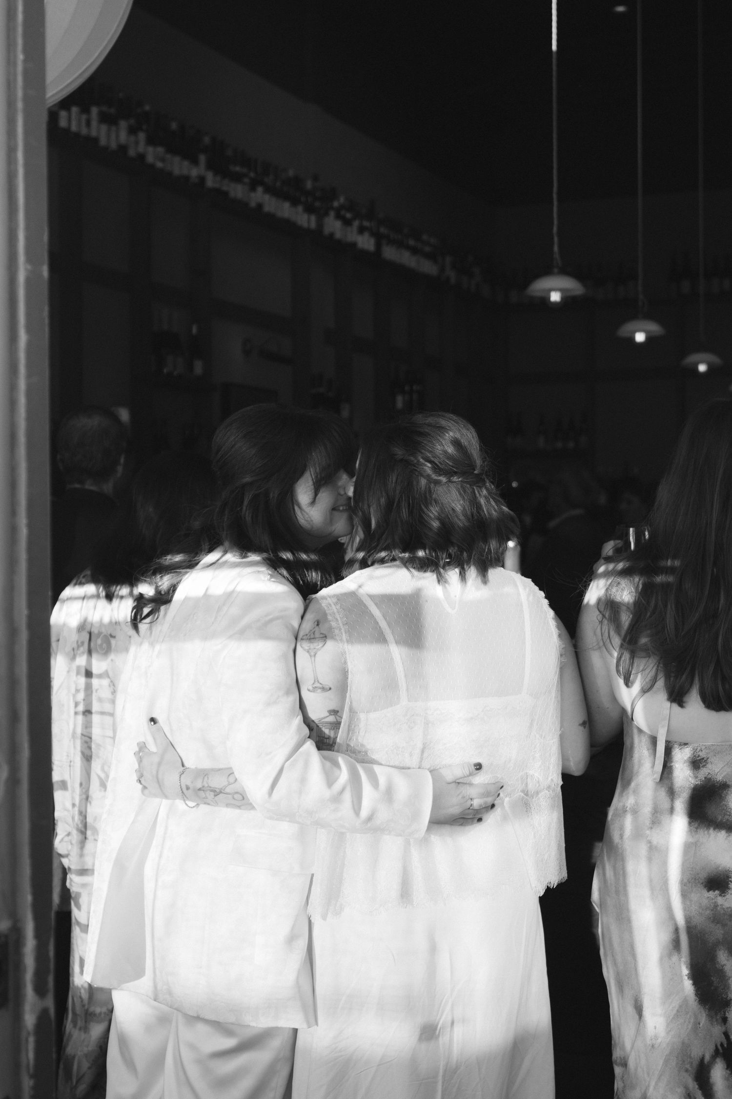 Multiple figures in white clothing shown through reflective glass panels creating an artistic effect.