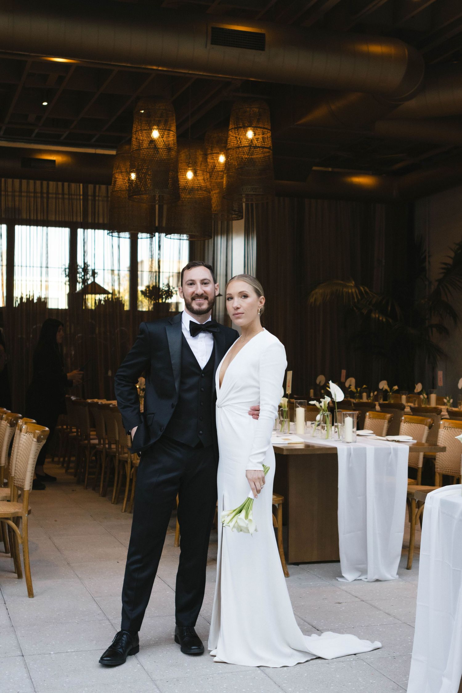 Wedding reception venue setup with white tablecloths and hanging pendant lights creating an elegant atmosphere.