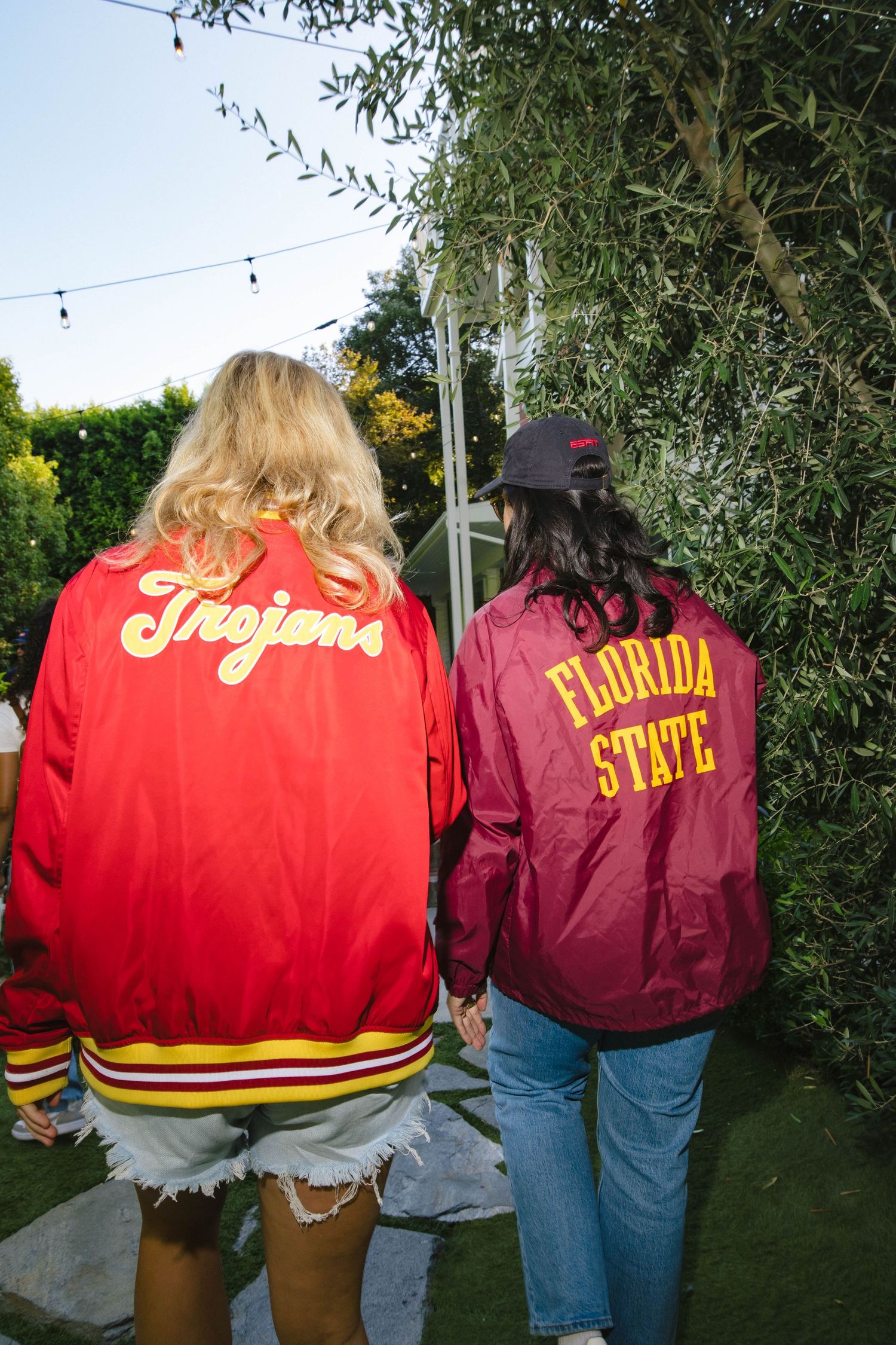 People wearing USC Trojans and Florida State varsity jackets shown from behind.