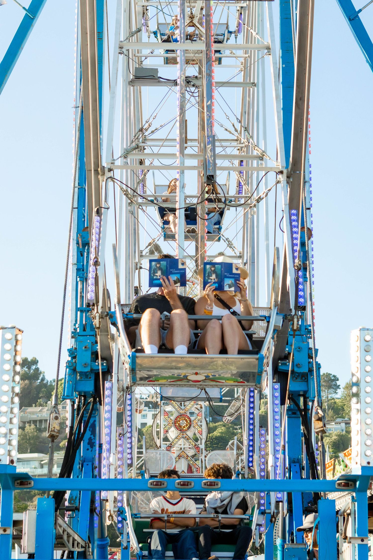 Amusement park ride with blue structural elements against a bright sky.