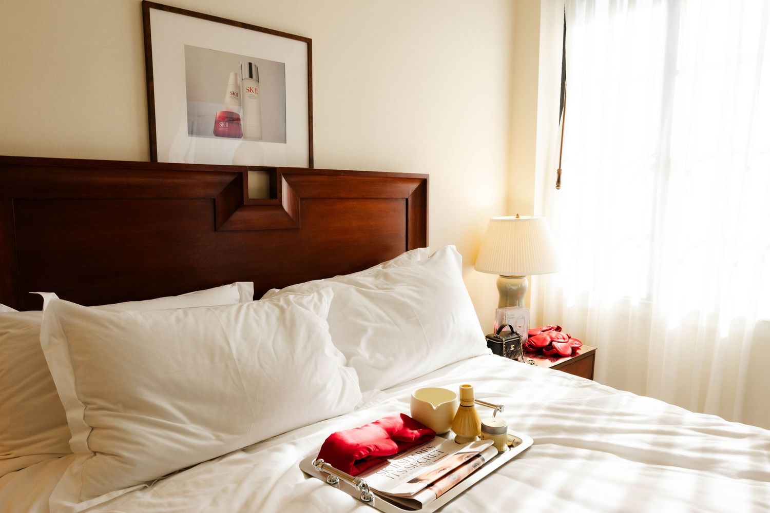 Crisp white bedding and pillows arranged neatly on a bed in a bright hotel room.