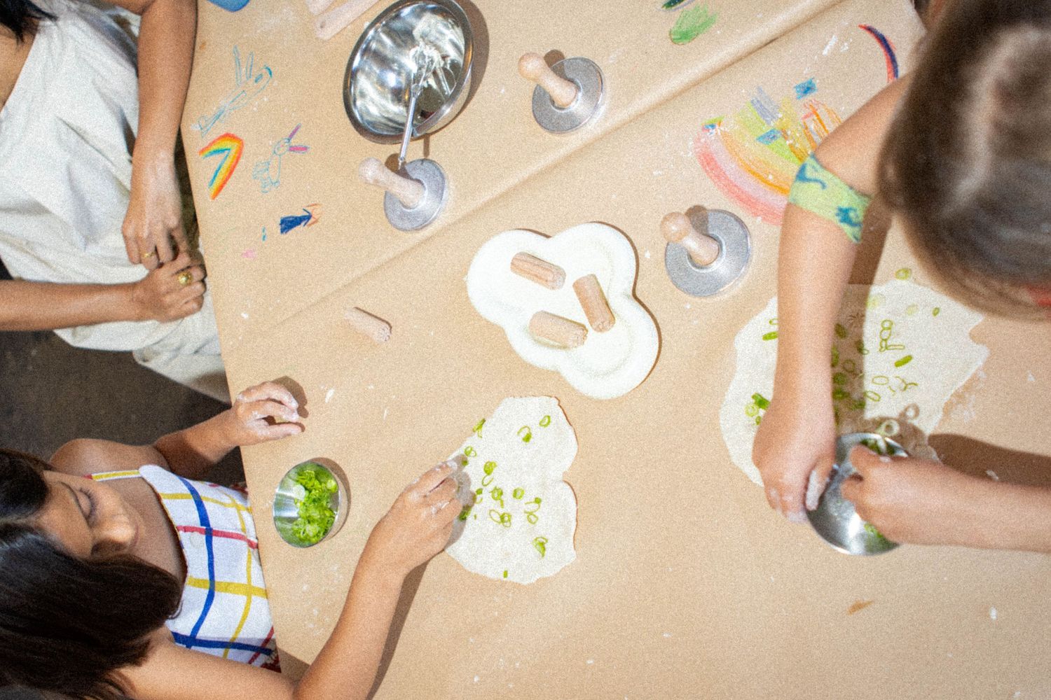 Overhead view of children doing arts and crafts activities at a table.