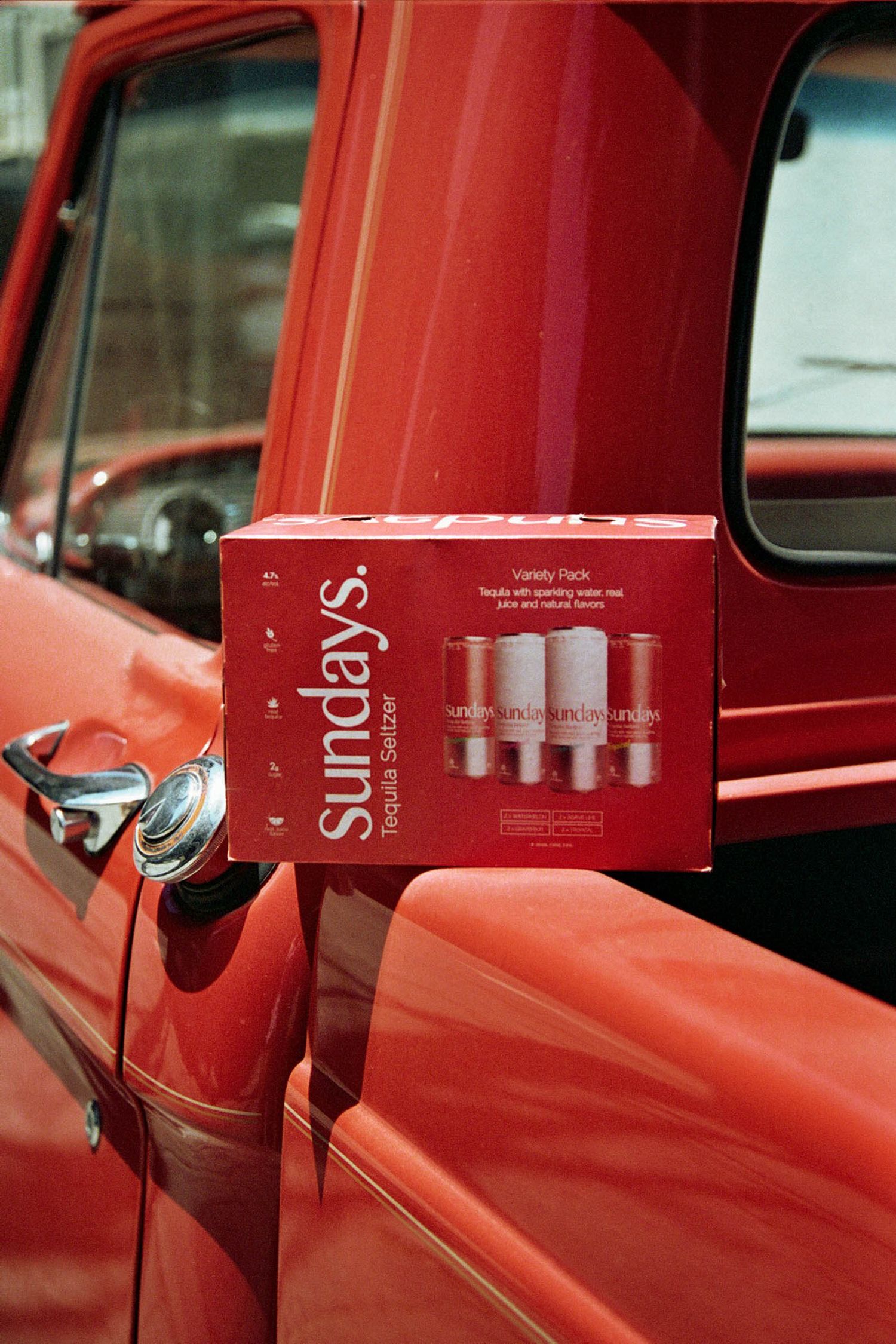 Close-up view of a vintage red car door with red boxes displayed in sequence.