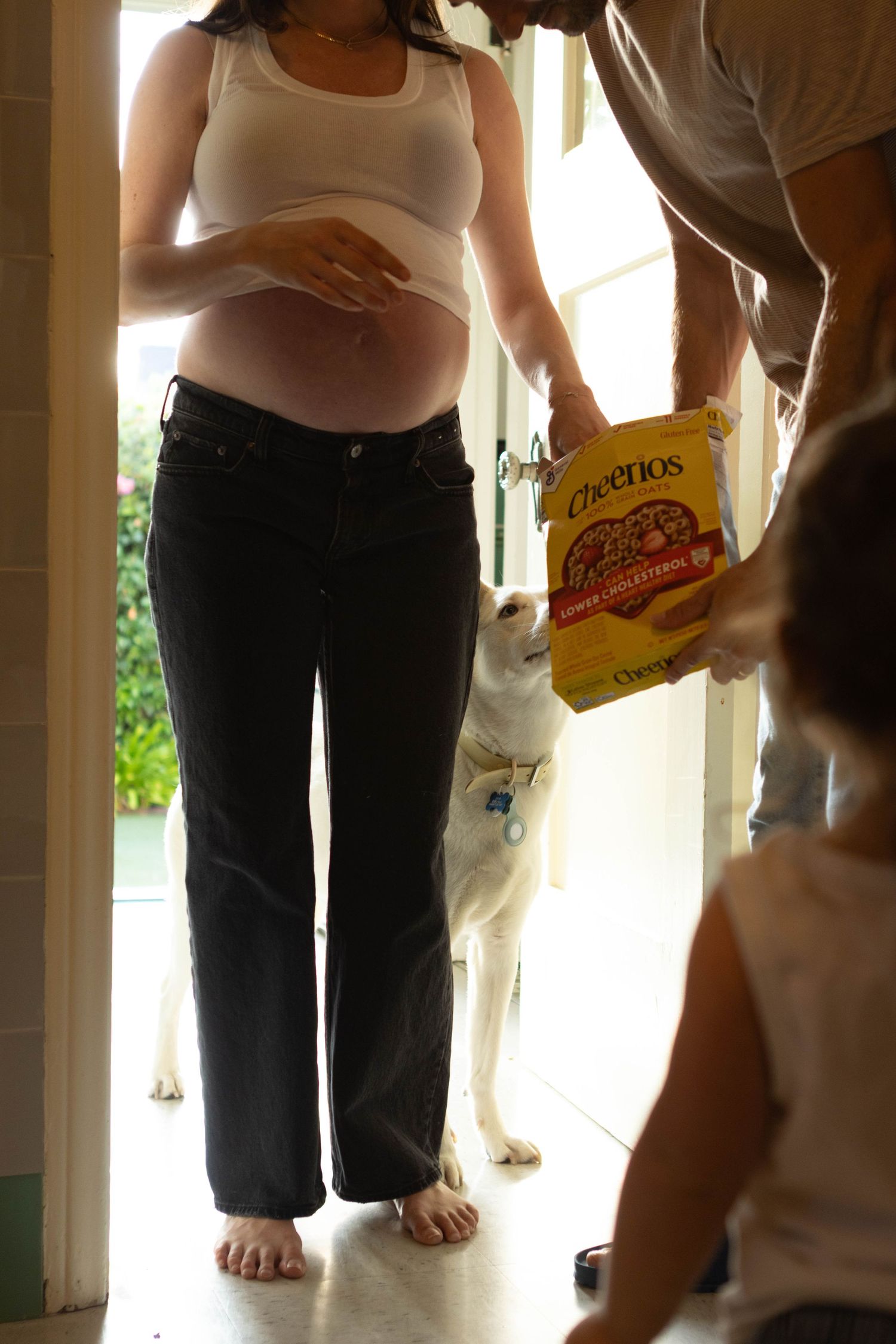 People standing in hallway holding snacks and drinks at casual gathering.