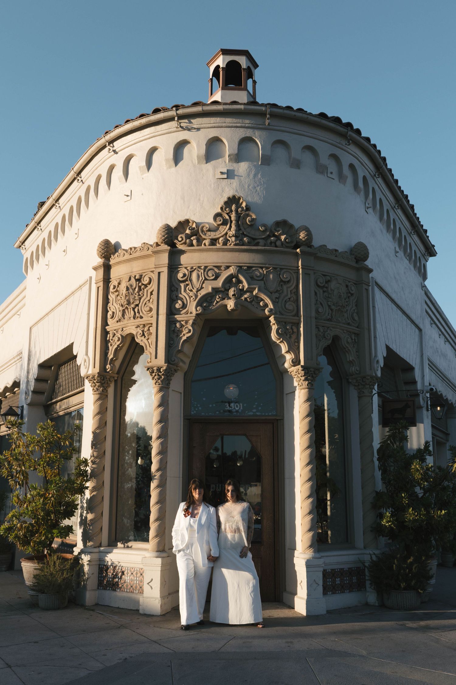 Classical white architecture with ornate columns and arches at a wedding venue.
