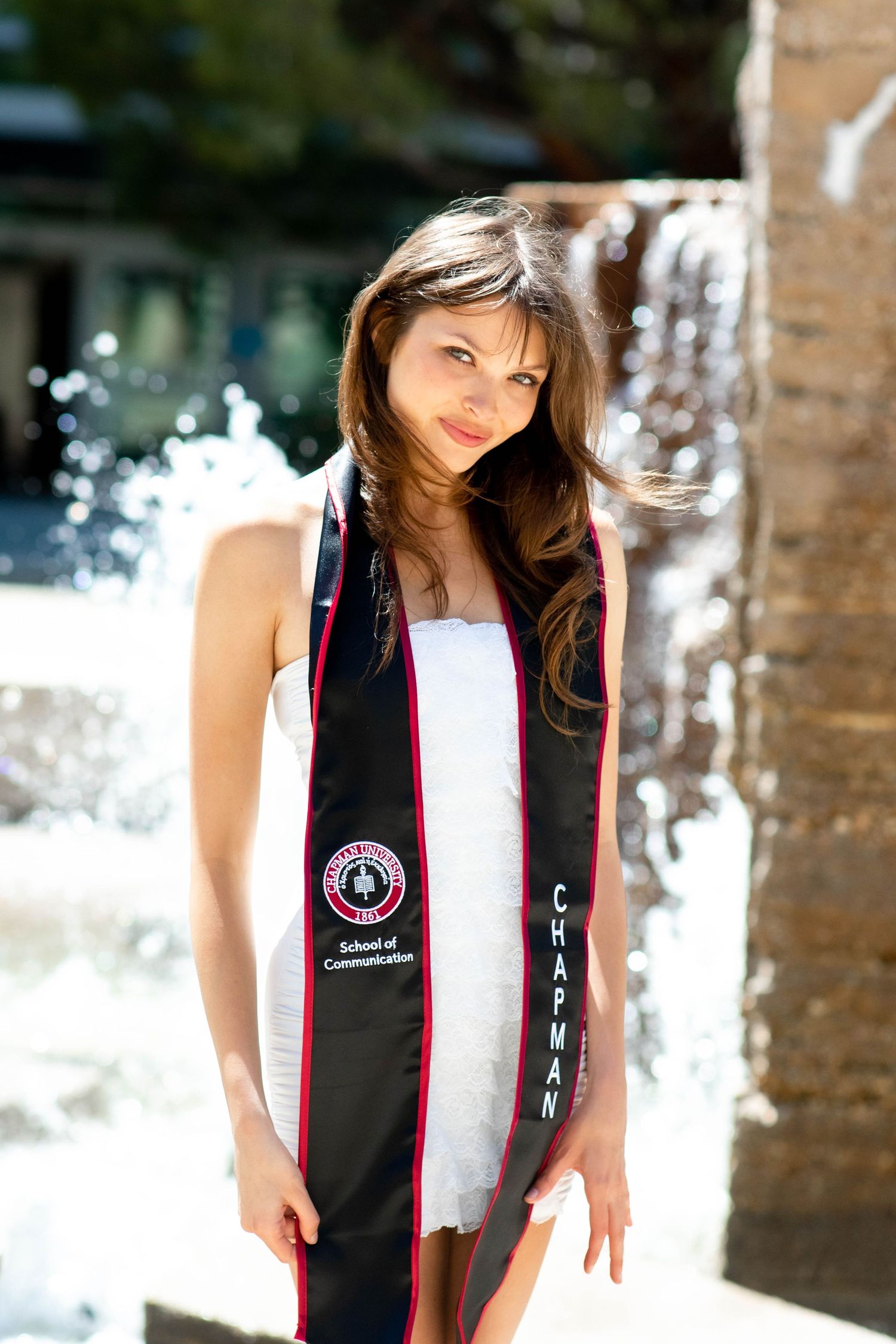 Graduate wearing black and white stole during outdoor photo session.
