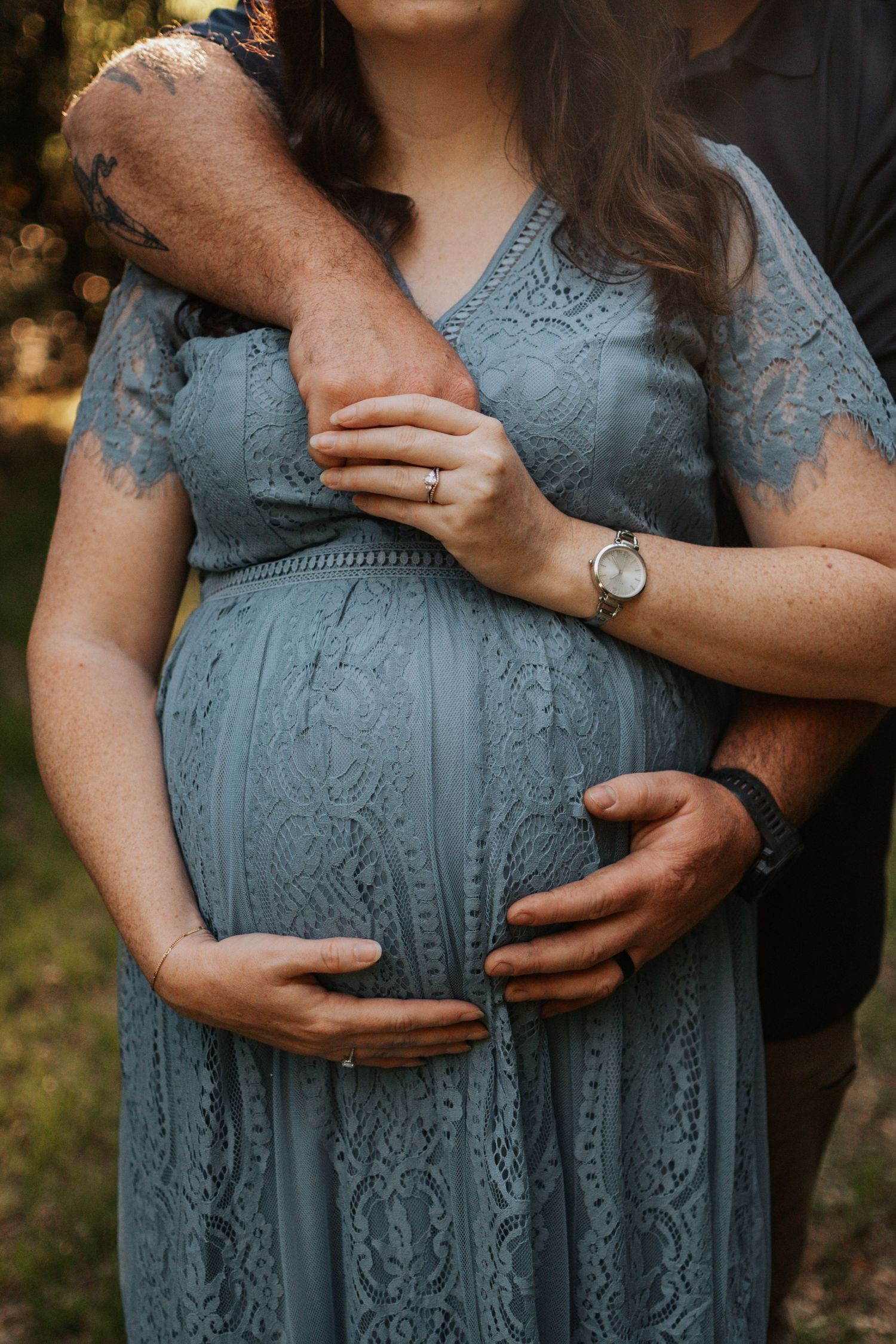 Close-up of a baby bump with parents' hands resting on it. Intimate maternity session in Kathleen, GA captured by C + F Photography.