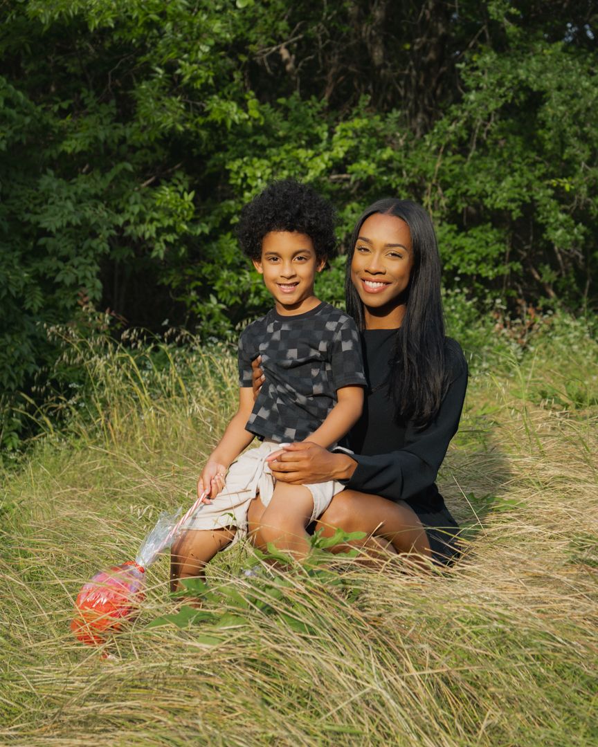 Candid outdoor portrait session in tall grass with heart-shaped lollipop prop.