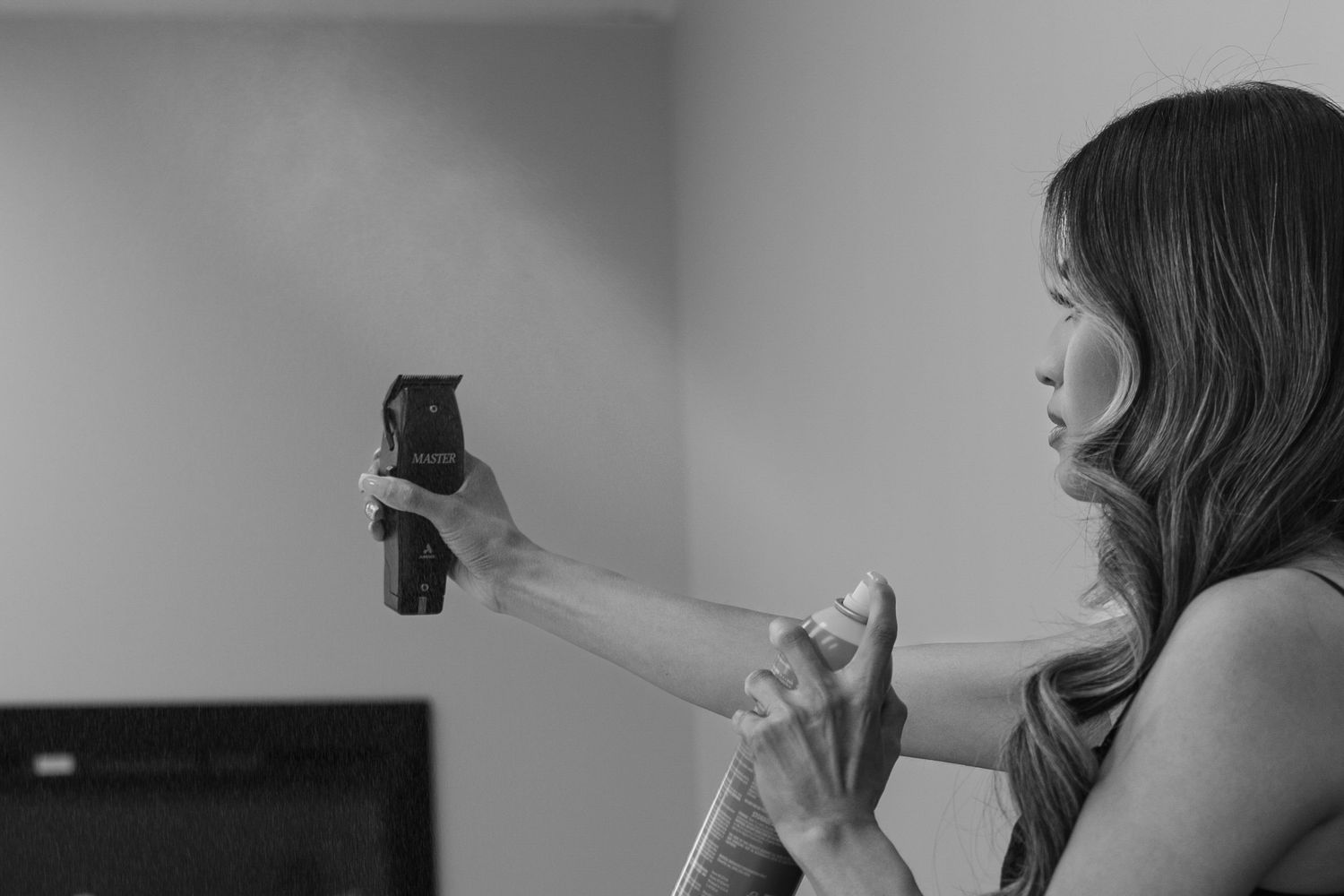 Woman holding a black handgun with both hands outstretched in a black and white indoor photo.