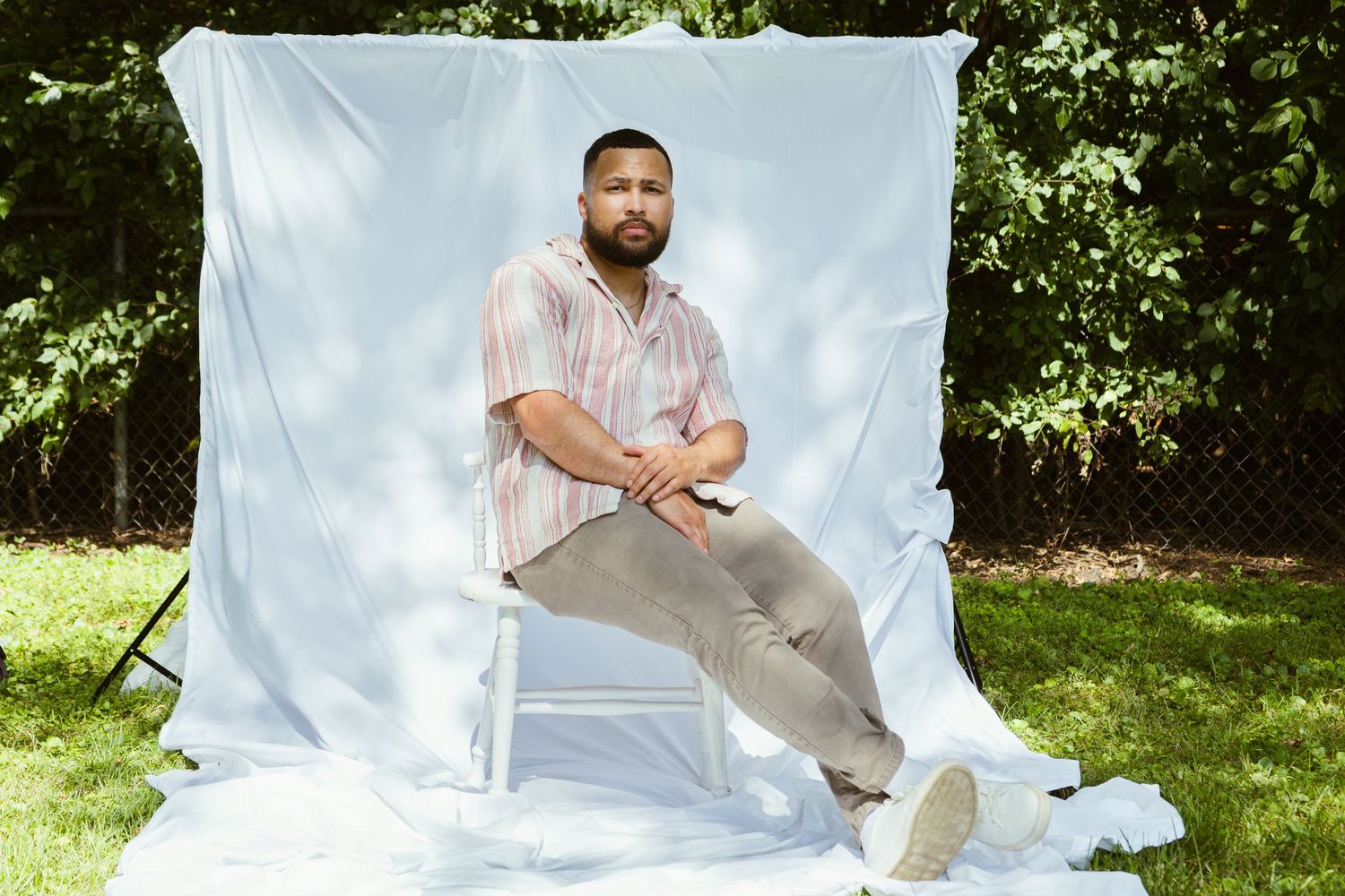 Professional outdoor editorial photoshoot setup with white backdrop and natural garden surroundings.