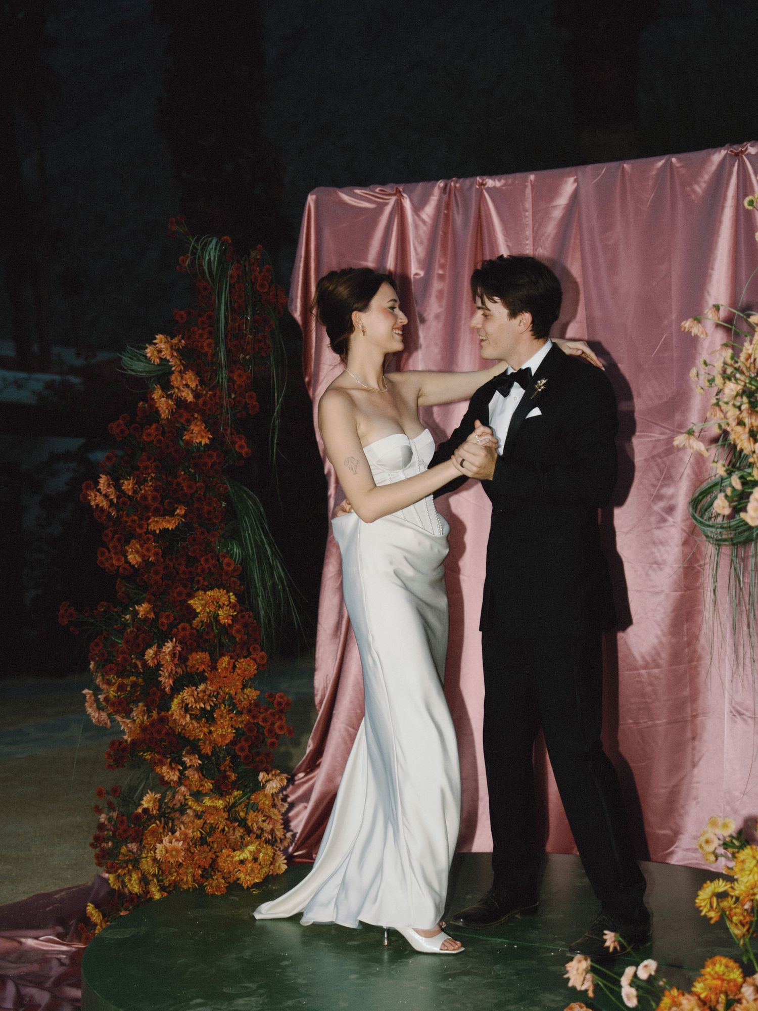 Wedding couple dancing in front of a floral backdrop in the San Francisco Bay Area; a soft, film-inspired style; Mandarin Cantonese English.