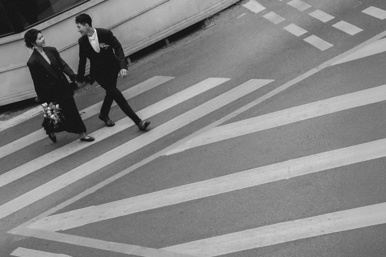Asian couple holding hands crossing a city street in a film-inspired style; San Francisco Bay Area; Mandarin, Cantonese, English.