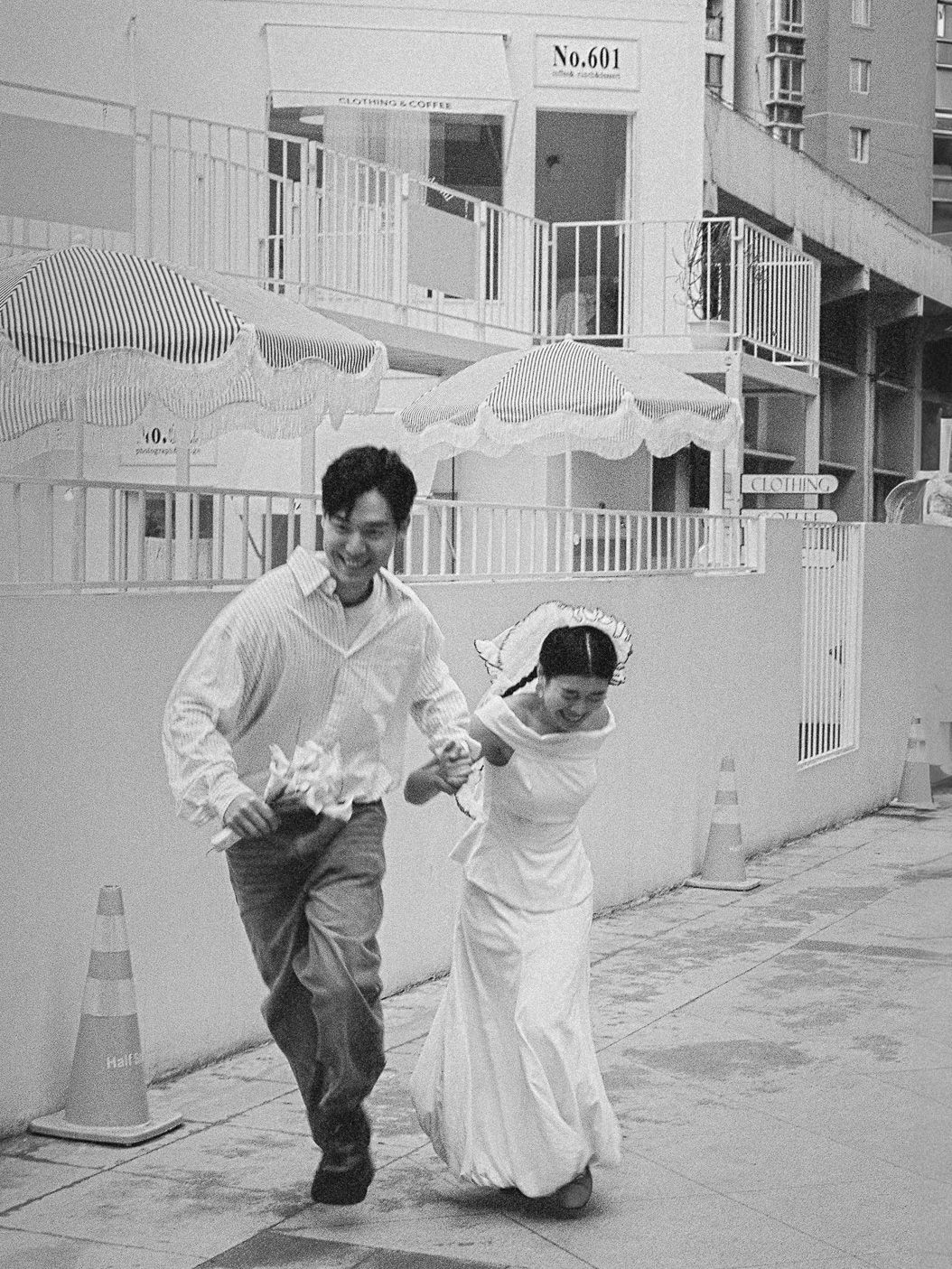 Asian couple running playfully in a city walkway in a film-inspired style; San Francisco Bay Area; Mandarin, Cantonese, English.