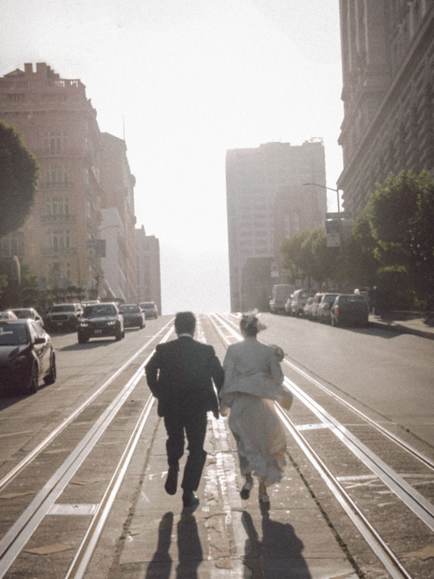 Asian couple running up a sunlit city street in a film-inspired style; San Francisco Bay Area; Mandarin, Cantonese, English.