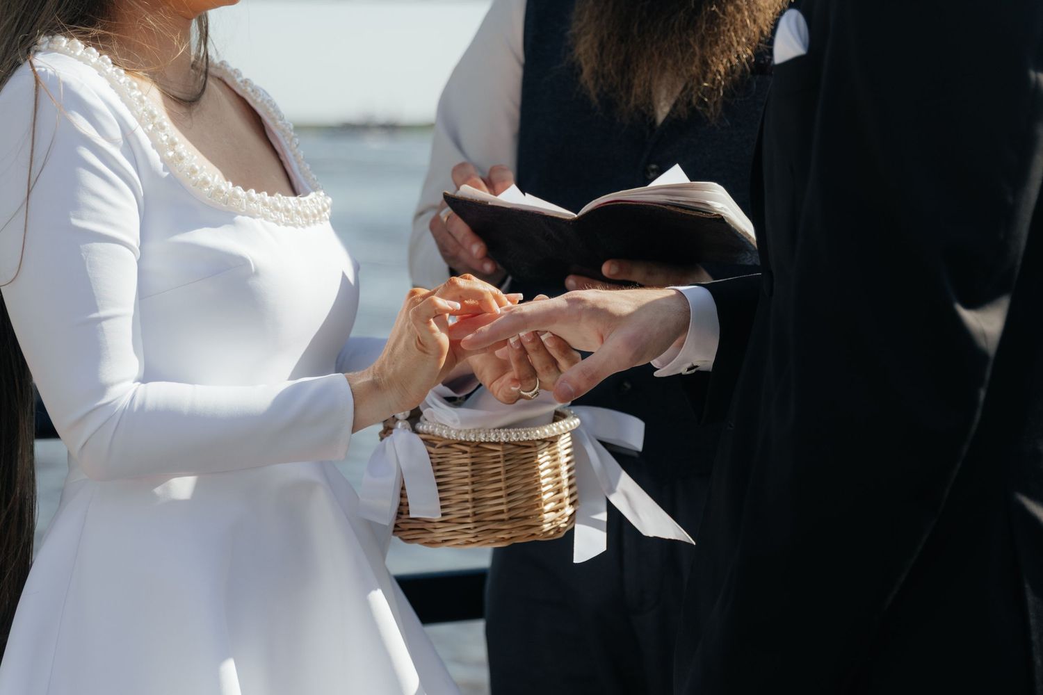 Bride and groom exchanging rings during riverwalk ceremony.