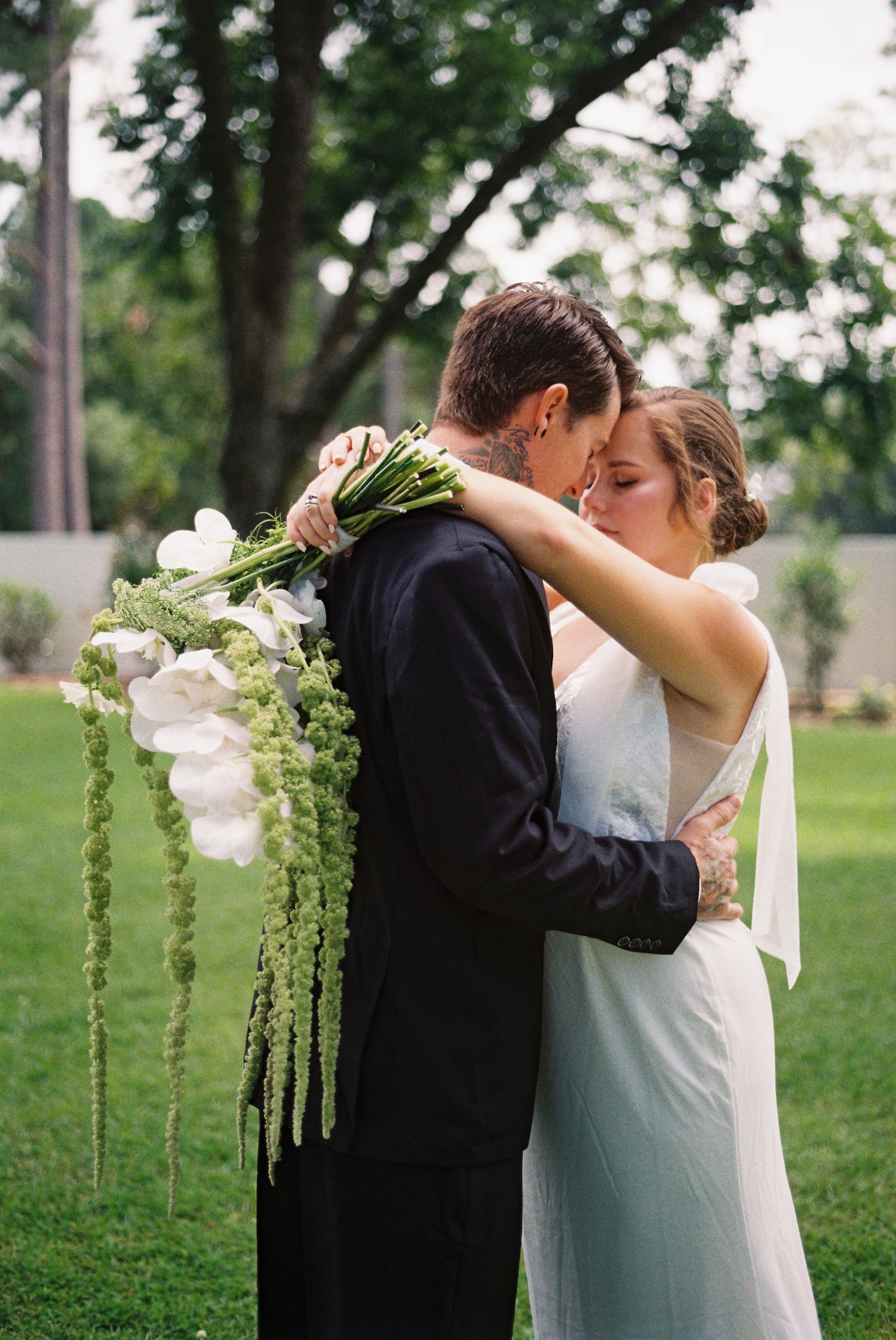 Elegant outdoor wedding scene with cascading white flowers and greenery.