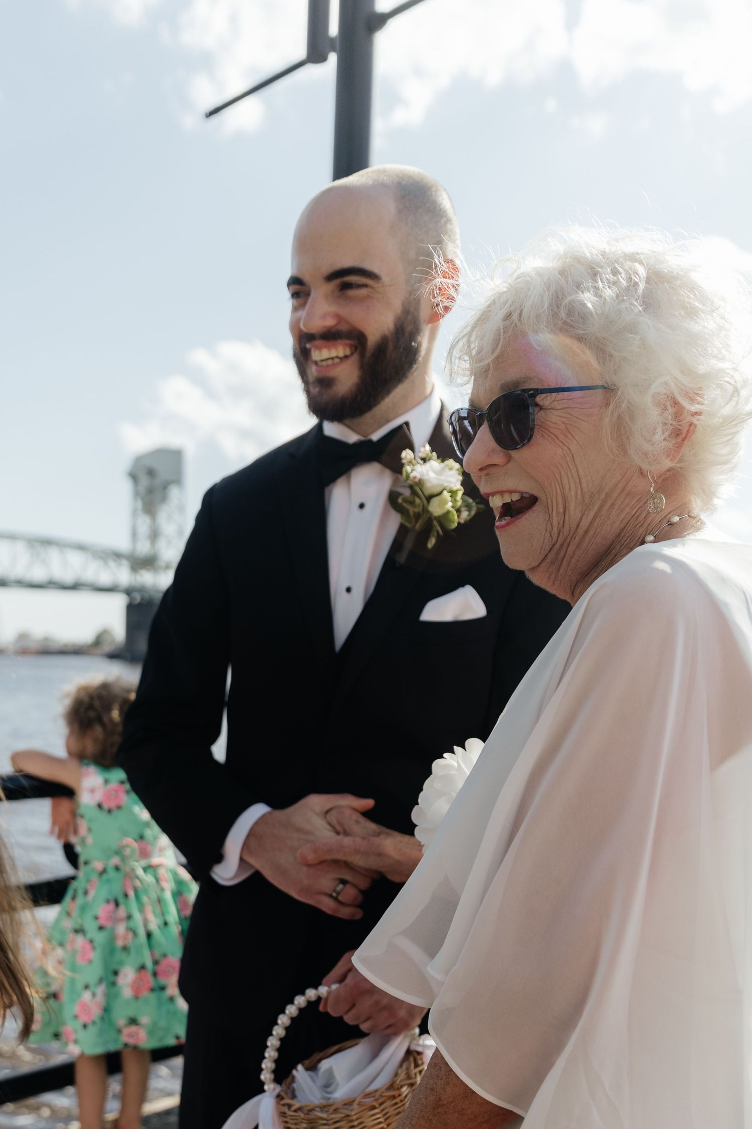 Wedding guests sharing joyful moment during outdoor ceremony.