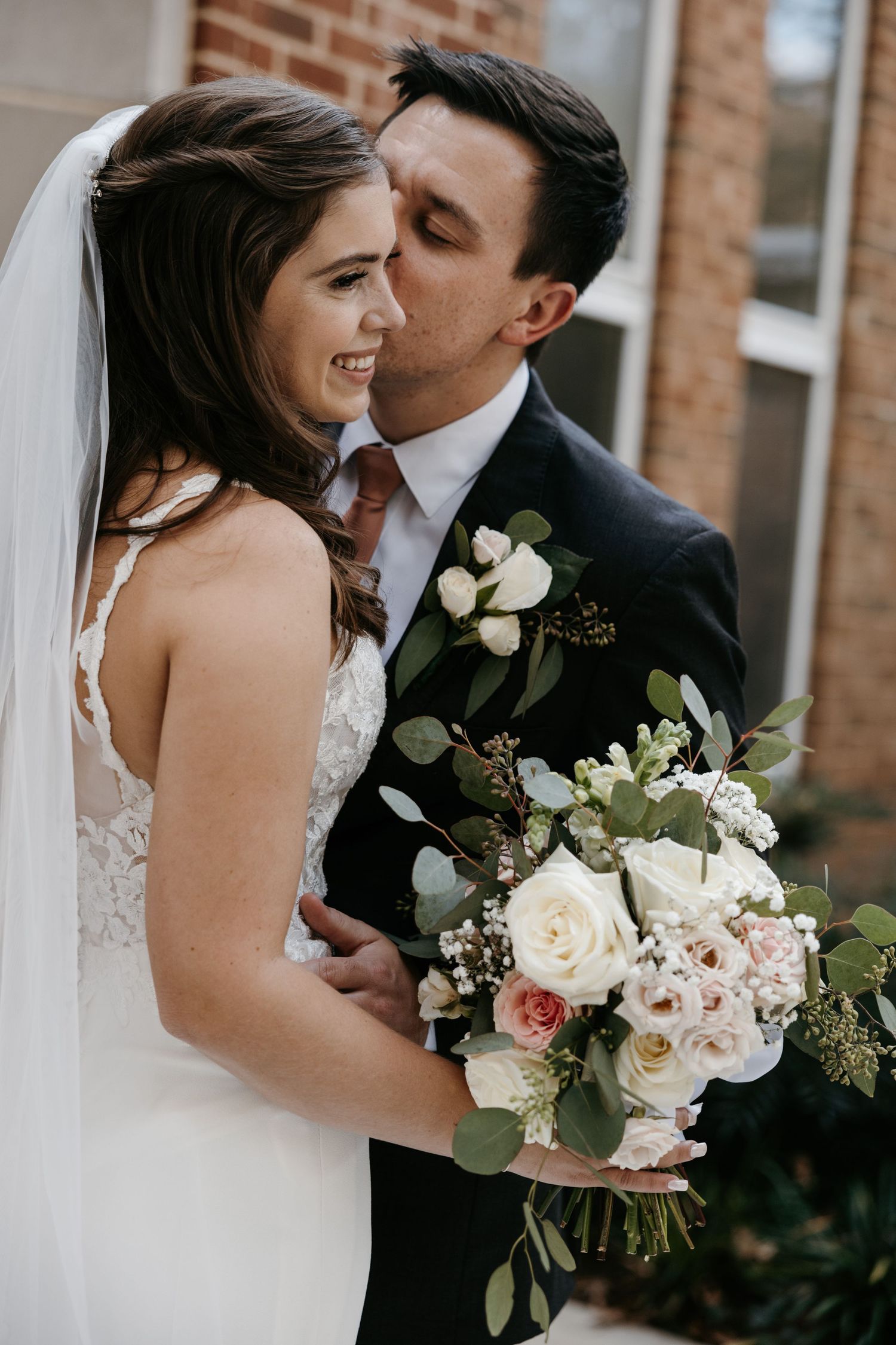 Romantic wedding portraits featuring a beautiful white rose and greenery bouquet.