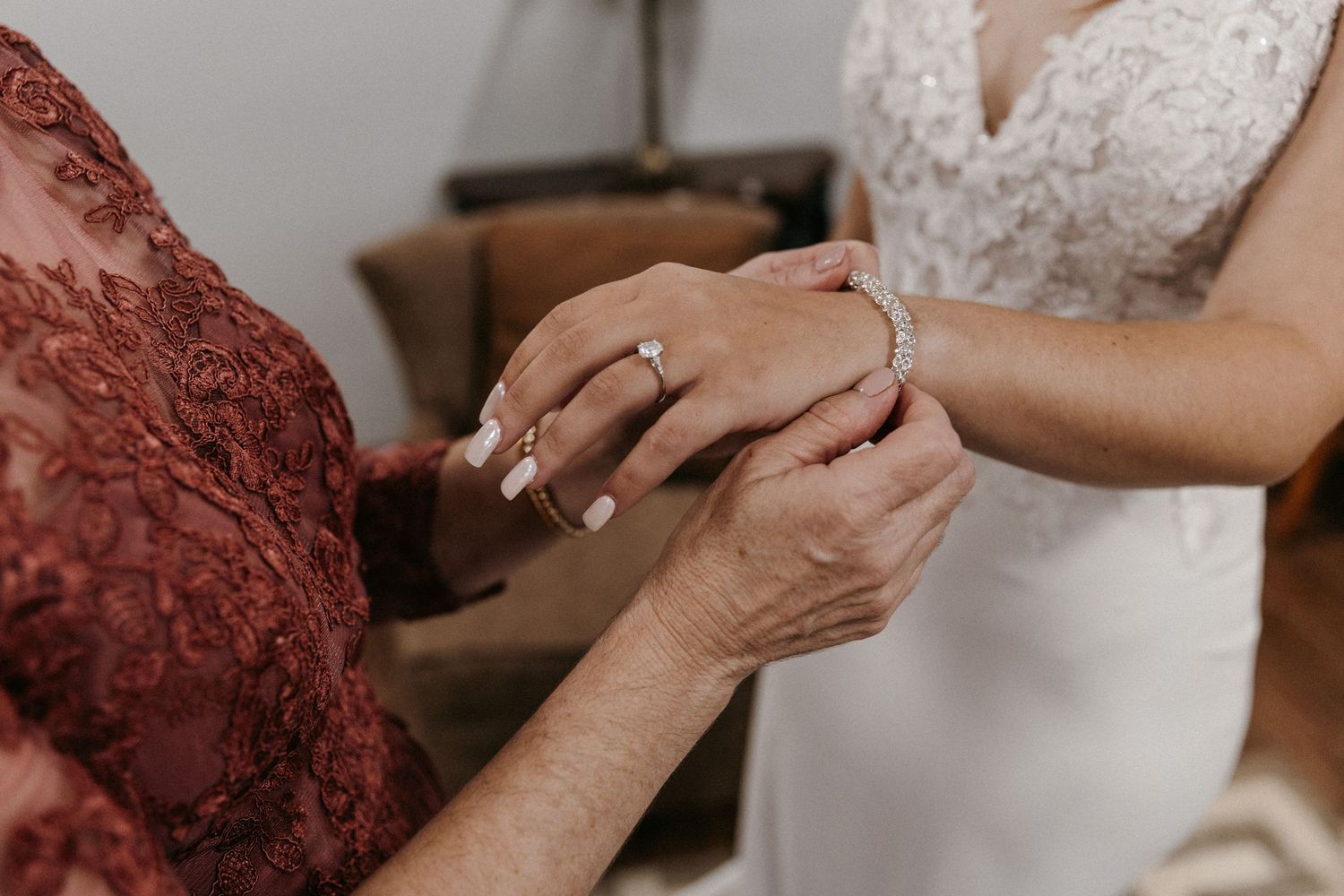 Close up of hands clasped together showing emotion during a wedding getting ready moment.