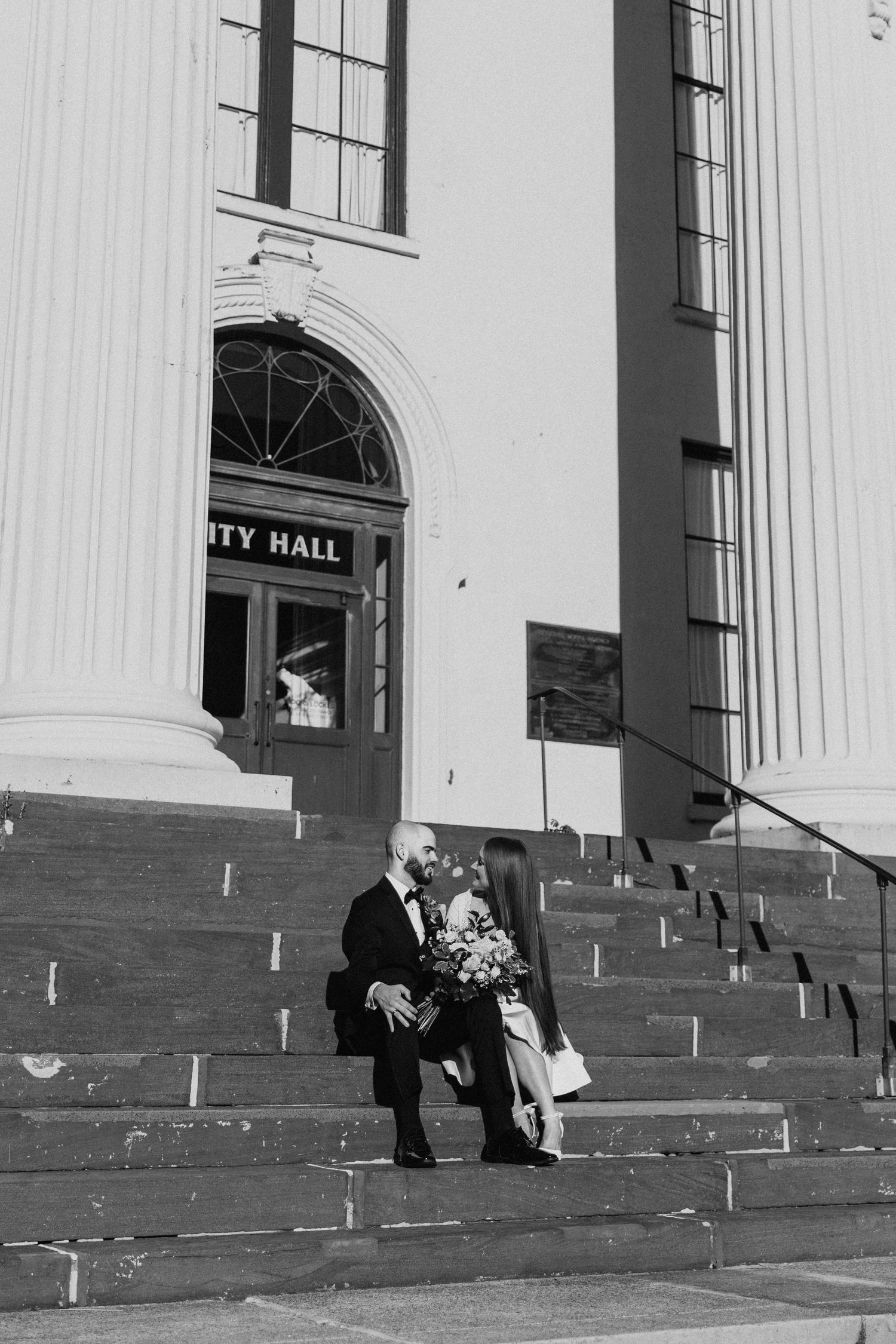 Bride and groom sharing a sweet moment on the steps of city hall.