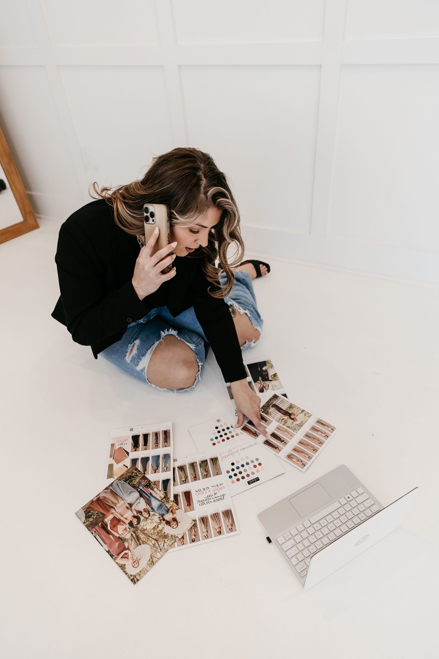 Overhead view of someone reviewing photographs while working on laptop.