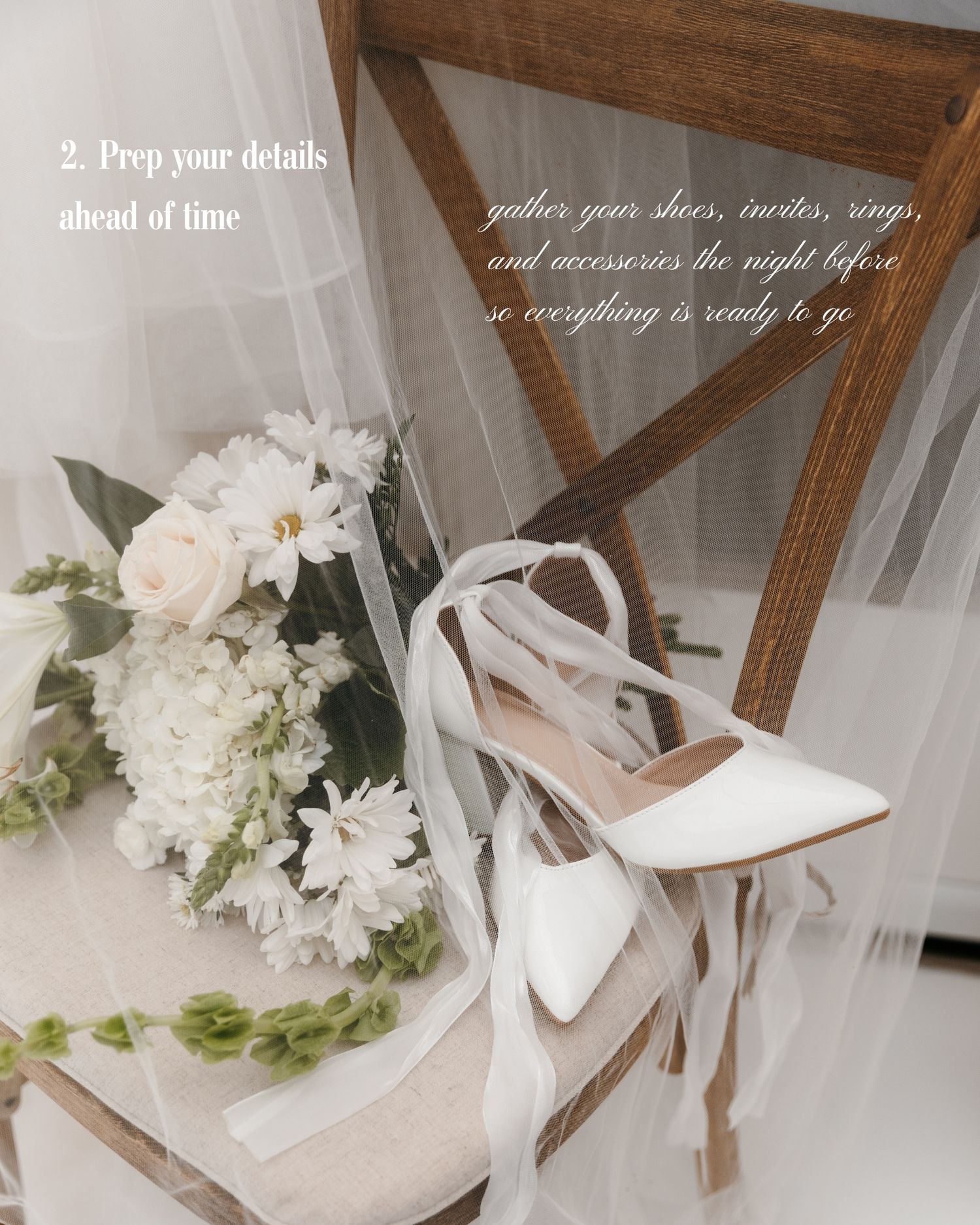White bridal heels with ribbon ties rest on a wooden chair beside a white floral bouquet and flowing veil.