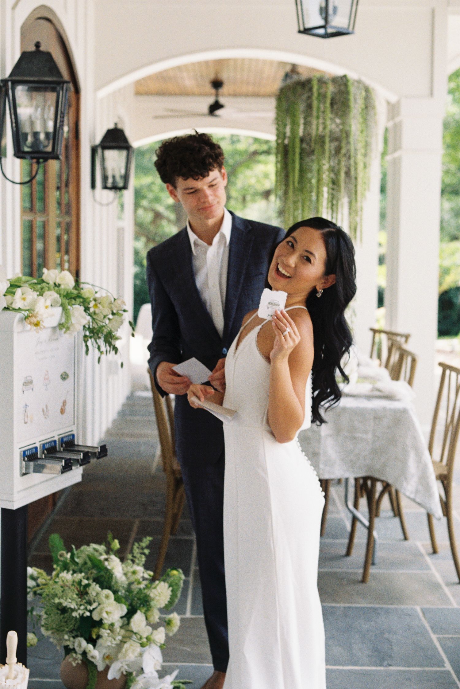 Couple posing with sticker after using a custom sticker vending machine on their wedding day.
