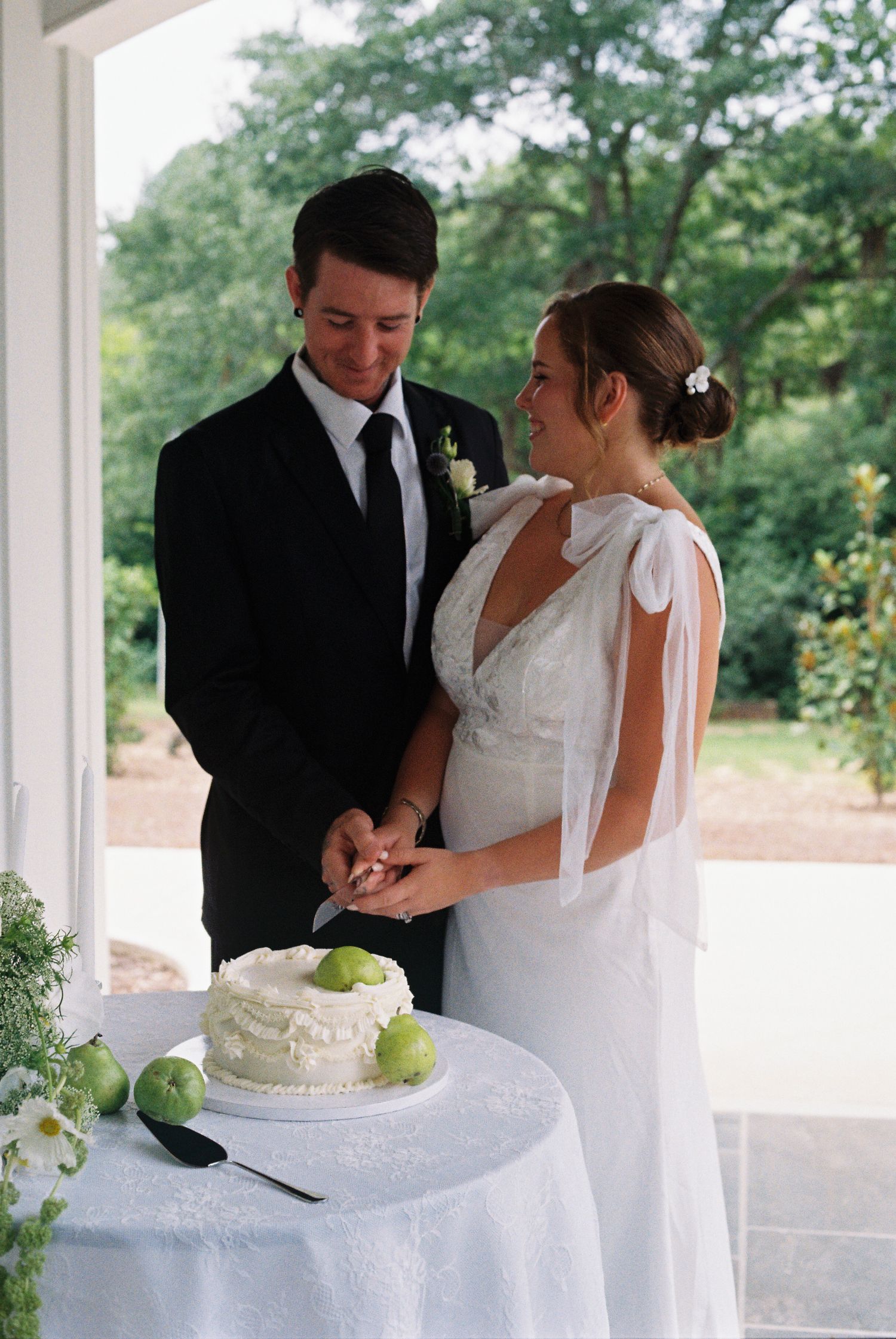 Wedding couple cutting their white tiered cake at an elegant reception.