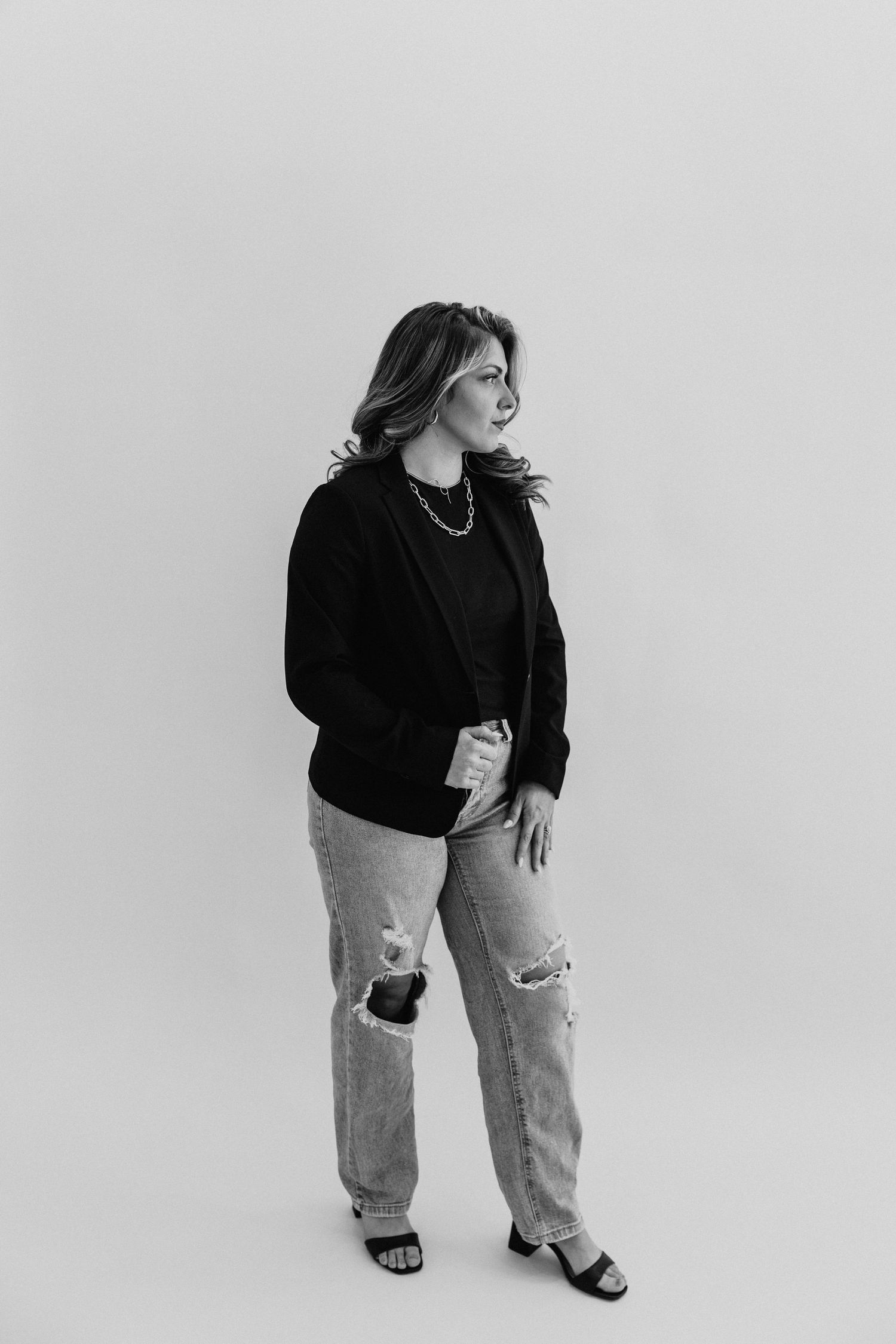 Black and white headshot portrait of woman in casual attire against plain background.