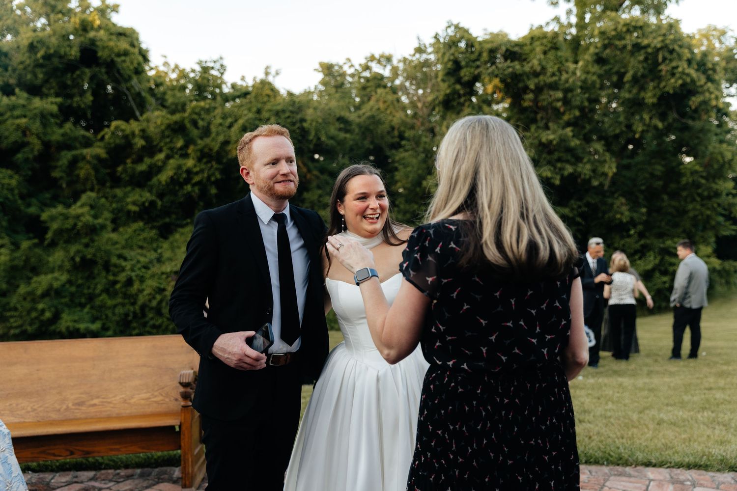 Guests celebrate with Bride during an outdoor wedding ceremony at sunset.
