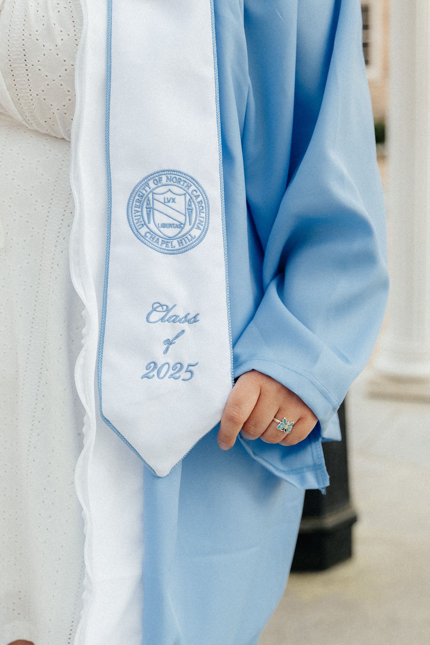 Close-up of light blue graduation stole showing Class of 2025 embroidery and university seal.