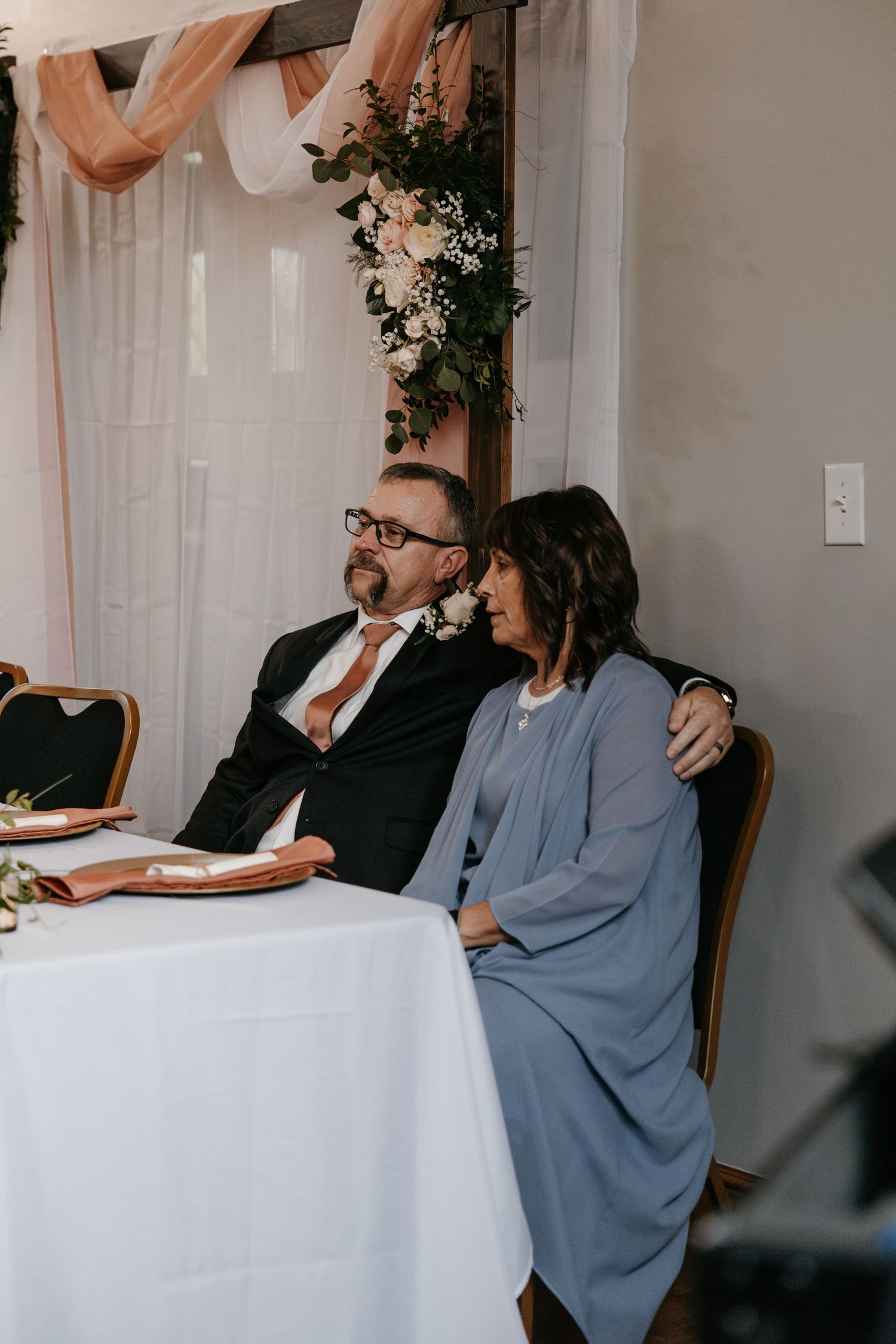 Wedding guests seated at tables during reception in a modern venue with white linens.